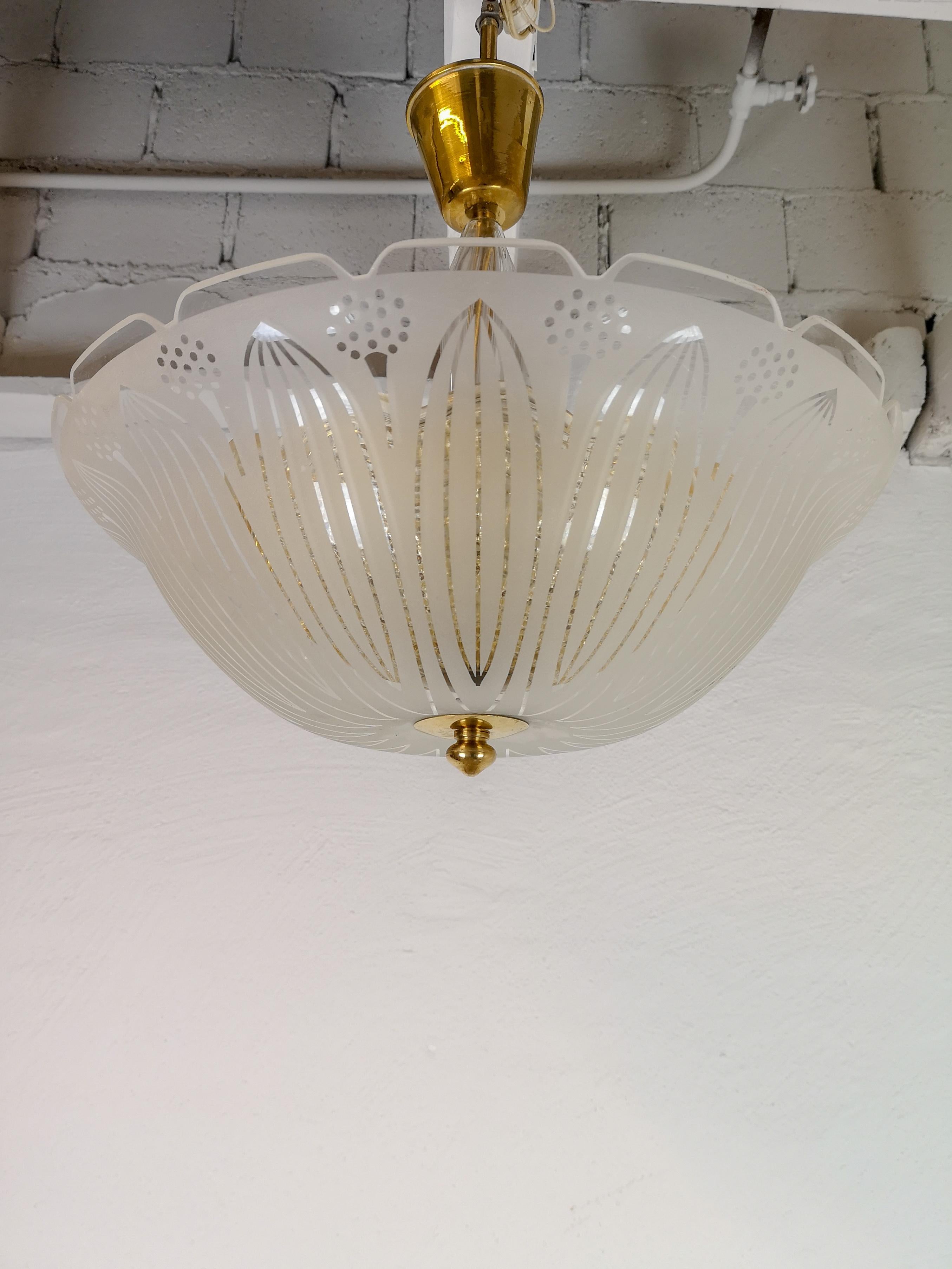 This large crystal and textured glass ceiling lamp with brass details was made in Sweden 1960s for Orrefors. 

Good condition.

Measures: H 53/35 cm D 40.

 