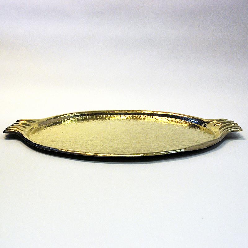 Lovely midcentury oval brass serving tray with shell shaped handles on the sides and higher edges all around the tray. From Sweden 1930/40s. Made of handhammered solid brass. Perfect for serving purpose or even for decoration. Lovely with brass