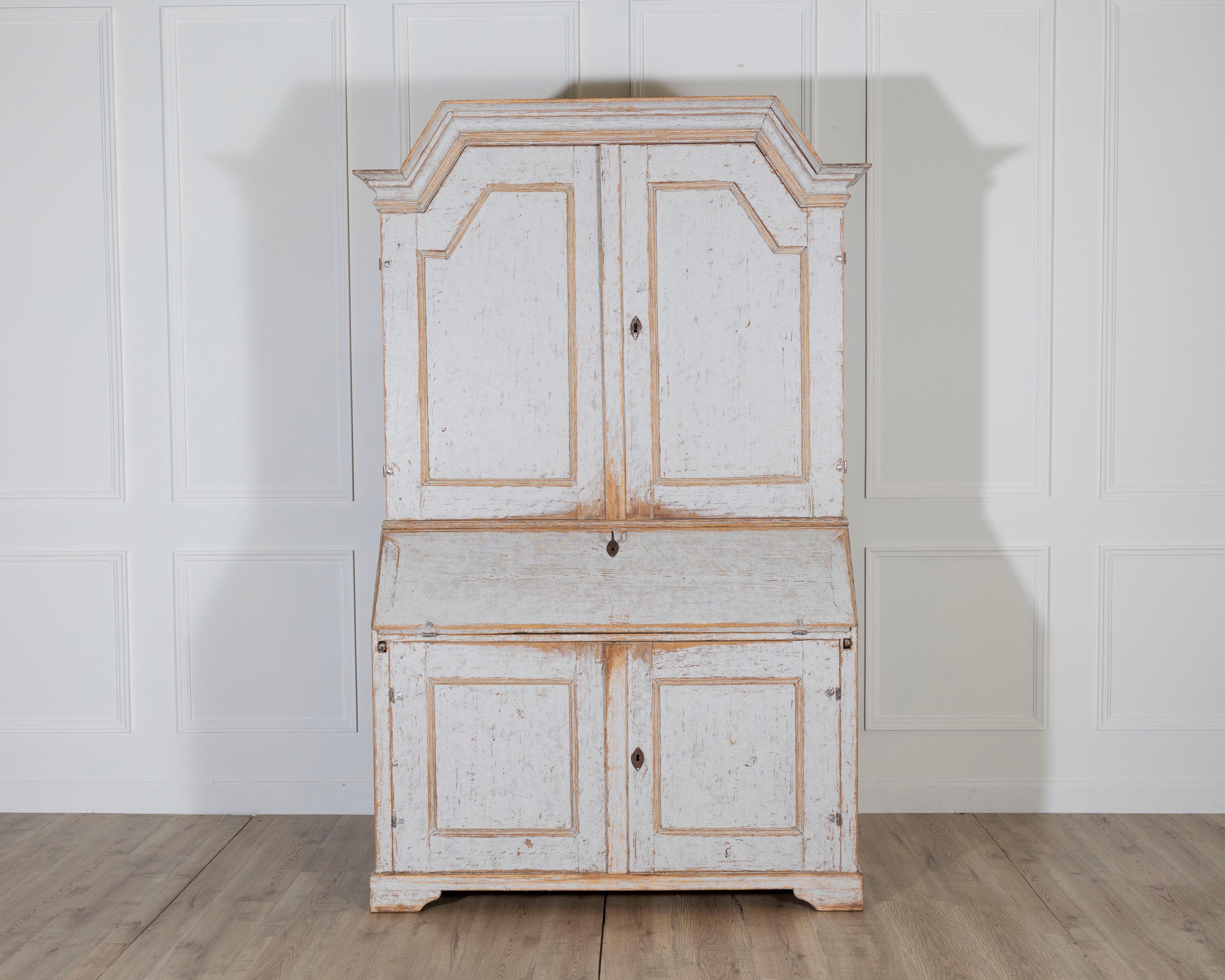 This impressive mid-19th century Swedish secretary from Värmland, dated 1854, is a striking example of Scandinavian craftsmanship and functional elegance. Monumental in scale and beautifully proportioned, the piece features a classic two-part form