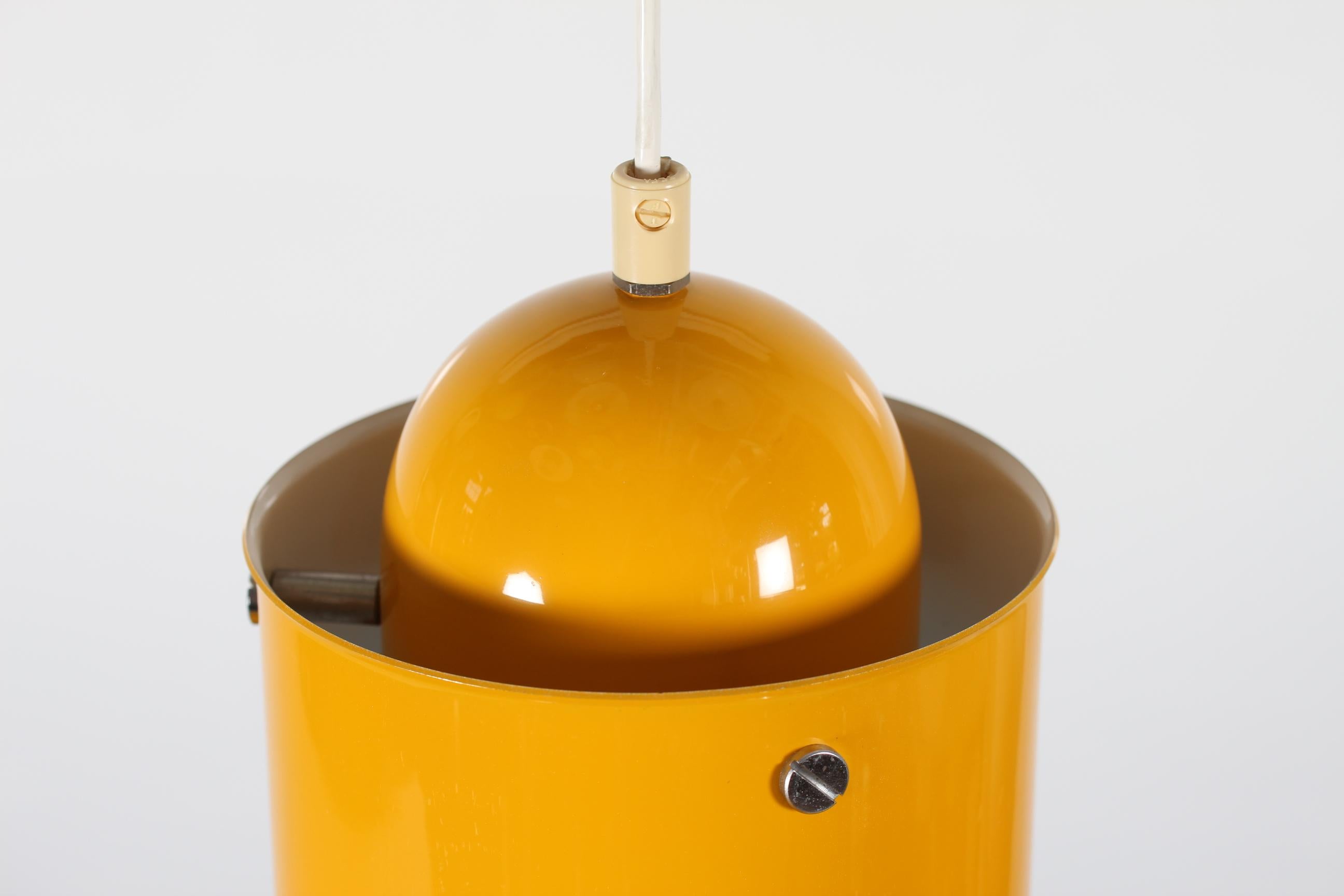 Grande lampe pendante moderniste ou rétro fabriquée par P. O. Ström en Suède dans les années 1970
Le pendentif en métal est laqué jaune soleil à l'extérieur et blanc à l'intérieur. 
Mesures : 
Hauteur : 32 cm + cordon
Diamètre : 55 cm

Très
