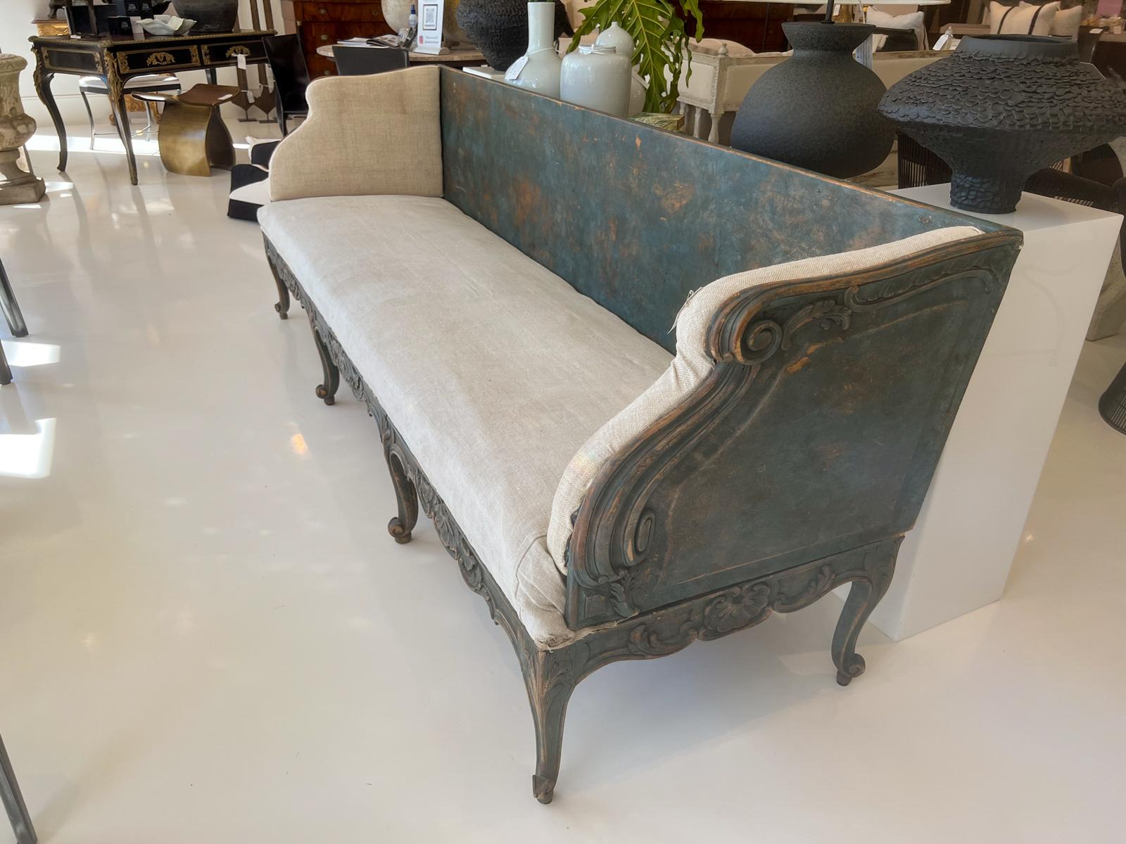 Banc à longue traîne en provenance de Suède. Magnifique finition dans les tons de bleu, joliment patinée. Rembourré en lin lin.