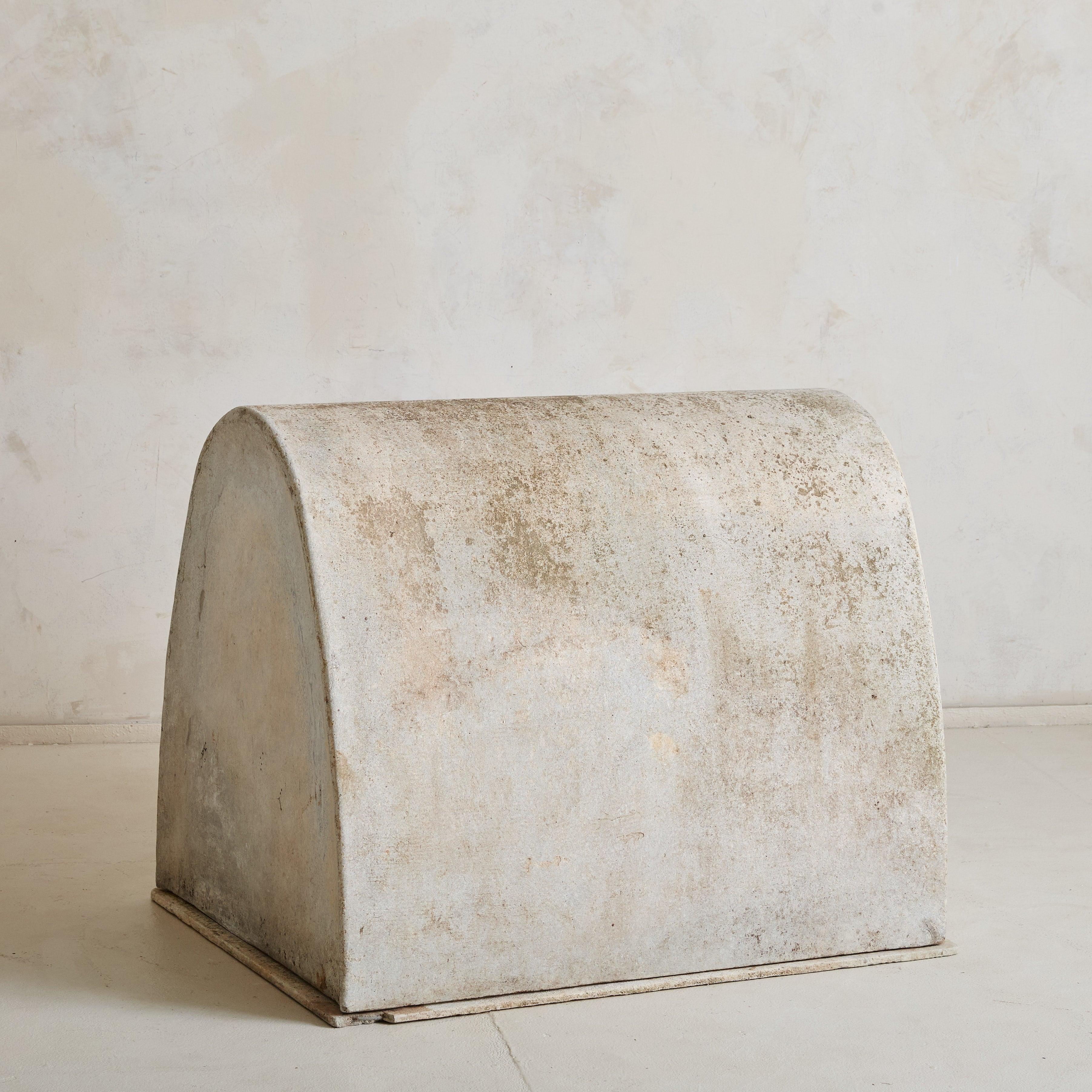 Eine seltene Hundehütte aus Beton aus den 1960er Jahren, entworfen vom bekannten Schweizer Designer Willy Guhl. Das Bauwerk besteht aus einem einfachen, länglichen Sockel, der von einem erhöhten Rundbogen gekrönt wird, der in einem zarten