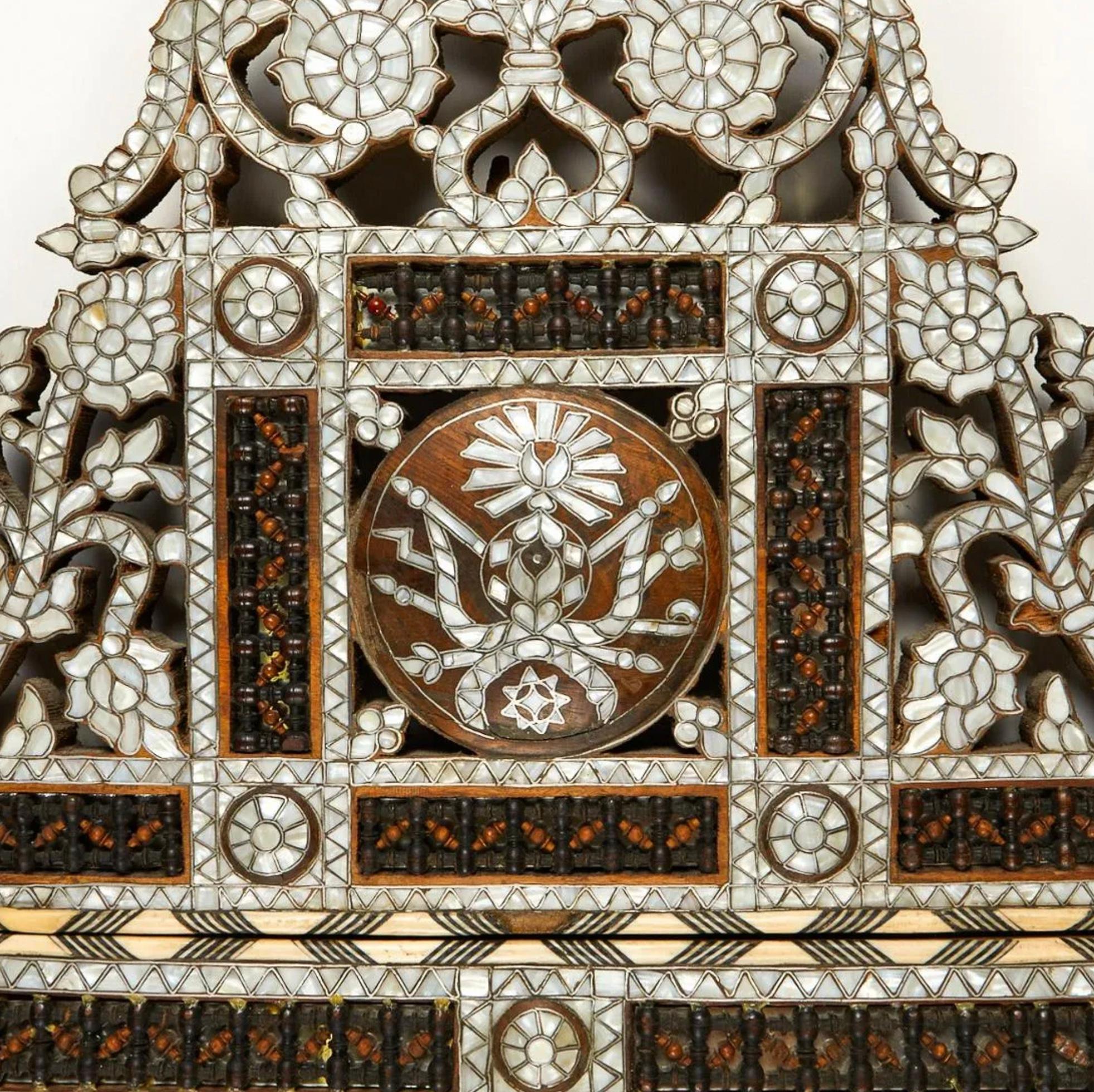 Large Syrian mother of pearl inlaid wooden mirror. The intricately carved wood is inlaid with geometric and floral designs in mother of pearl and shell with the intarsia method. With panels of mashrabiya style latticework throughout.

Provenance: