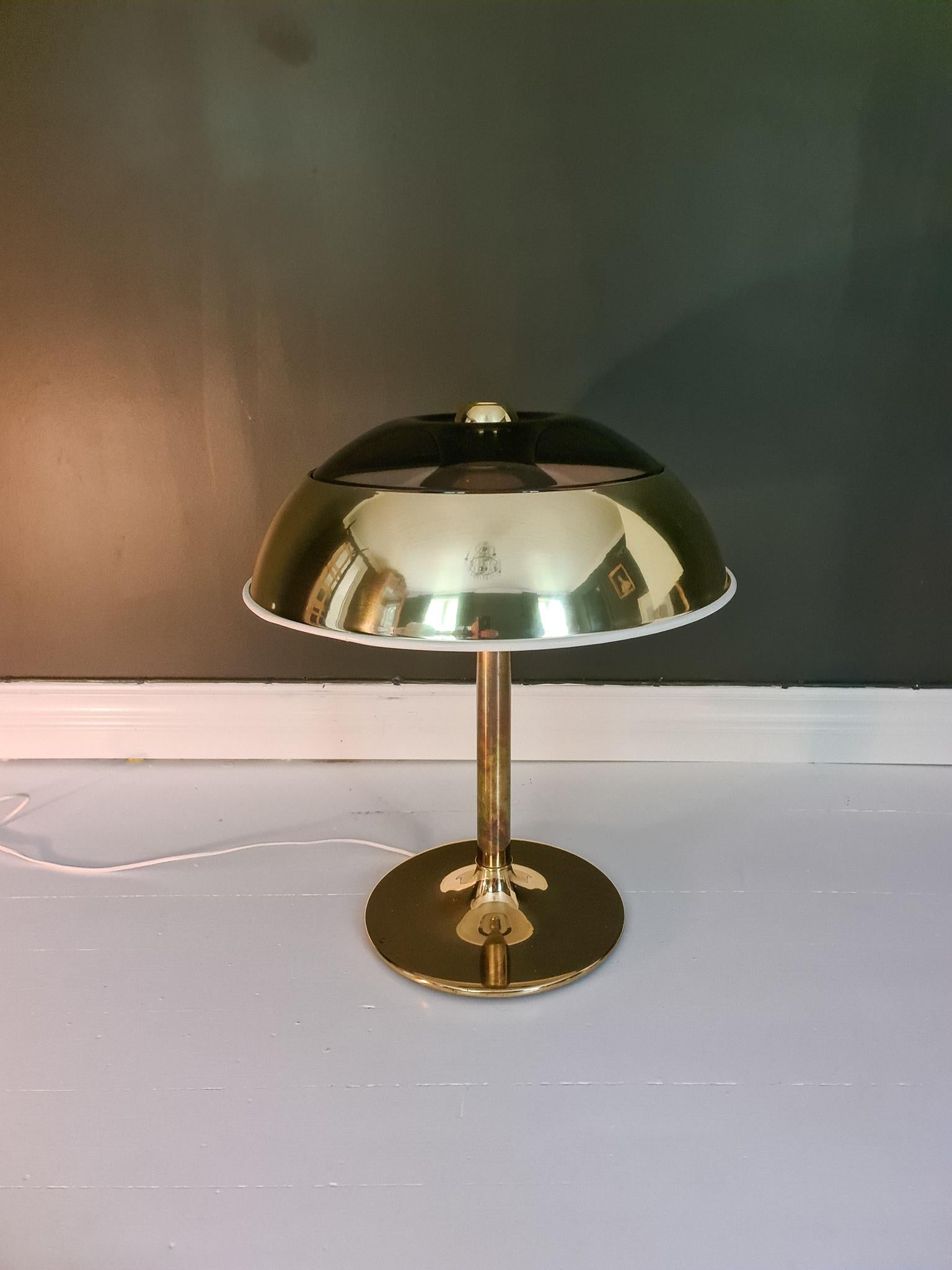 This large space table lamp in brass was manufactured at Fagerhults Belysning in Sweden, 1970s.
The shade is in brass metal and plastic, the rest of it in brass. When lit it gives a nice cool light. 

Good working condition, scratches on the