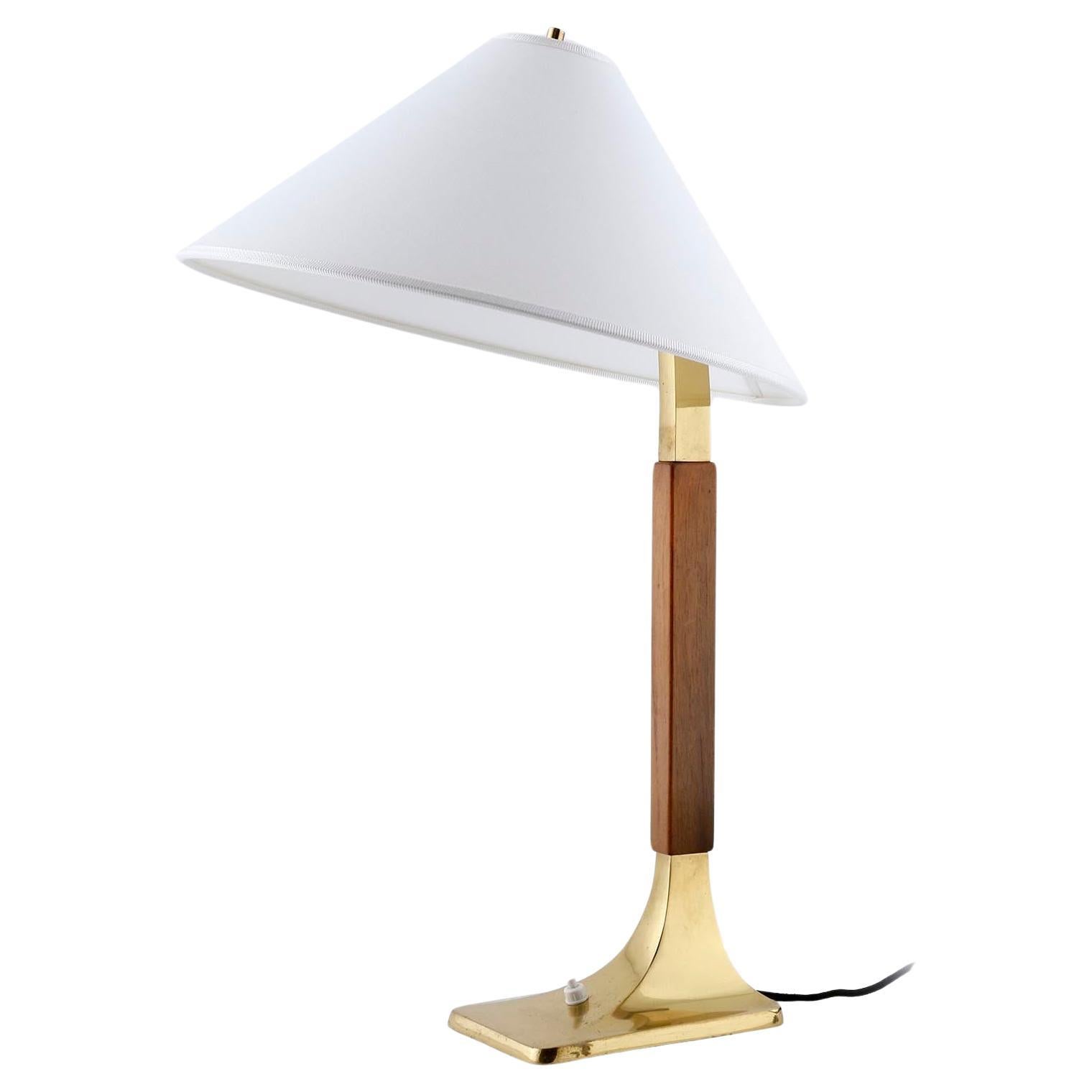 A fantastic table or desk lamp made of polished brass and walnut wood manufactured in Austria, Vienna, ca. 1960 (late 1950s or early 1960s). The piece is attributed to Austrian lighting maker J.T. Kalmar.
The lamp shade is renewed with a white