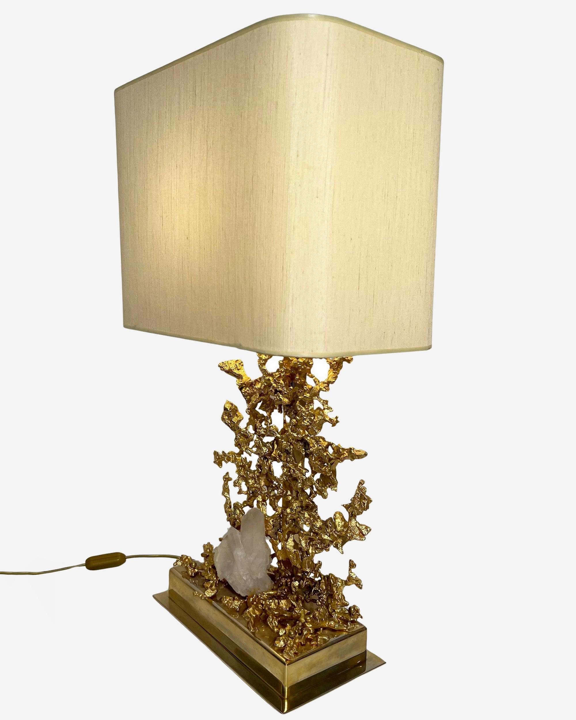Large table lamp in “exploded” bronze gilded with fine gold. Gold-plated brass frame.
It supports a block of rock crystal.
Original lampshade.

Biography

Claude Victor Boeltz, France (1937)

Claude-Victor Boeltz is born in 1937 in Paris. Complete