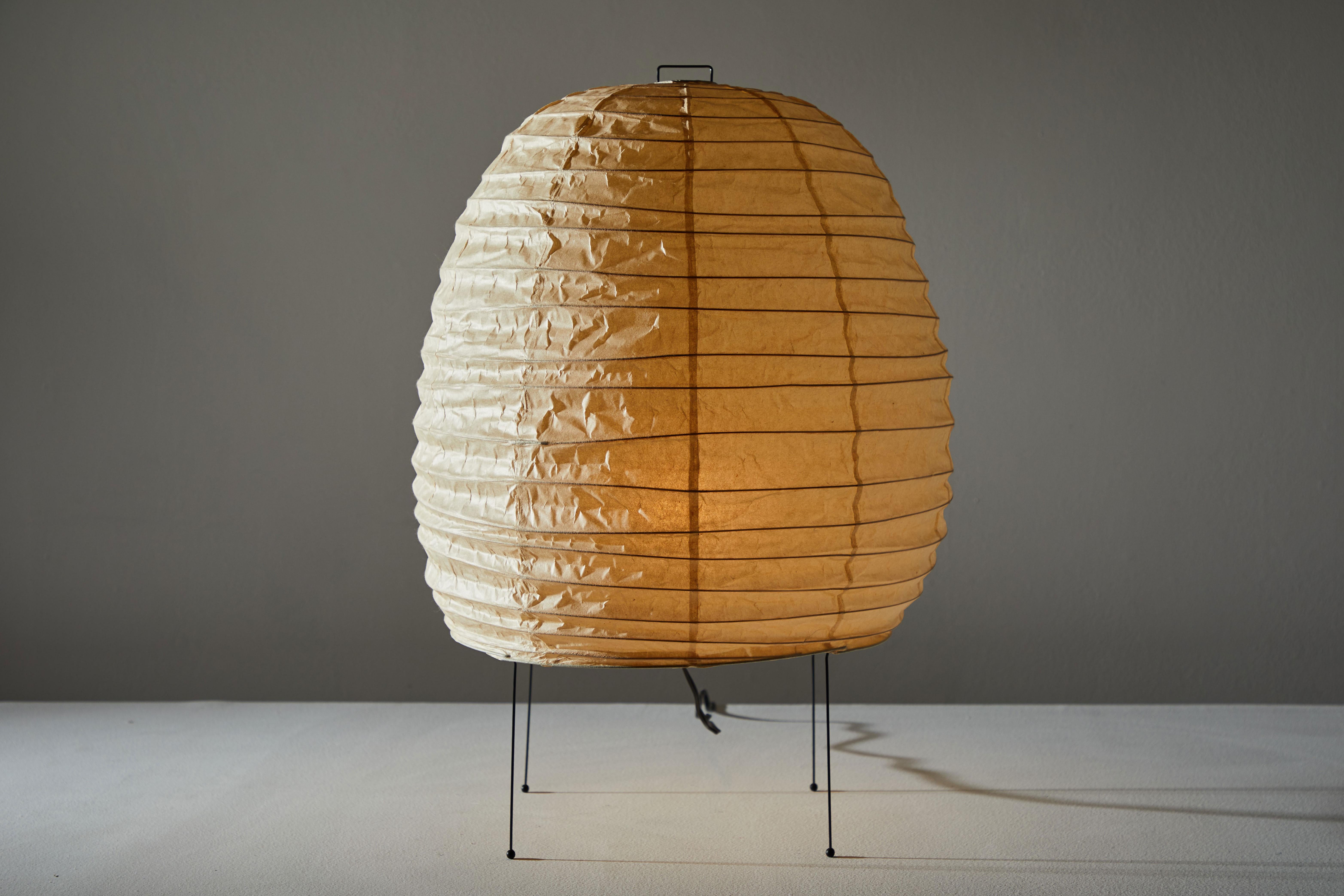 Large table lamp by Isamu Noguchi for Akari. Designed and manufactured in Japan circa 1950s. Rice paper and metal. Early edition with original sun/moon stamp. Original cord. Takes one E27 25w maximum bulb.