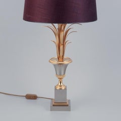 Large table lamp in brass with base in the shape of palm leaves.