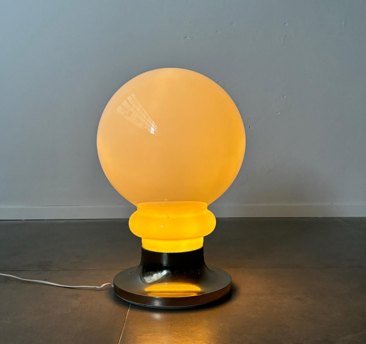 The large space age table lamp or floor lamp by Carlo Nason for Mazzega, crafted in the 1970s in Italy, is a striking embodiment of midcentury modern design. This impressive piece, made of opal glass and steel, resembles a colossal light bulb,