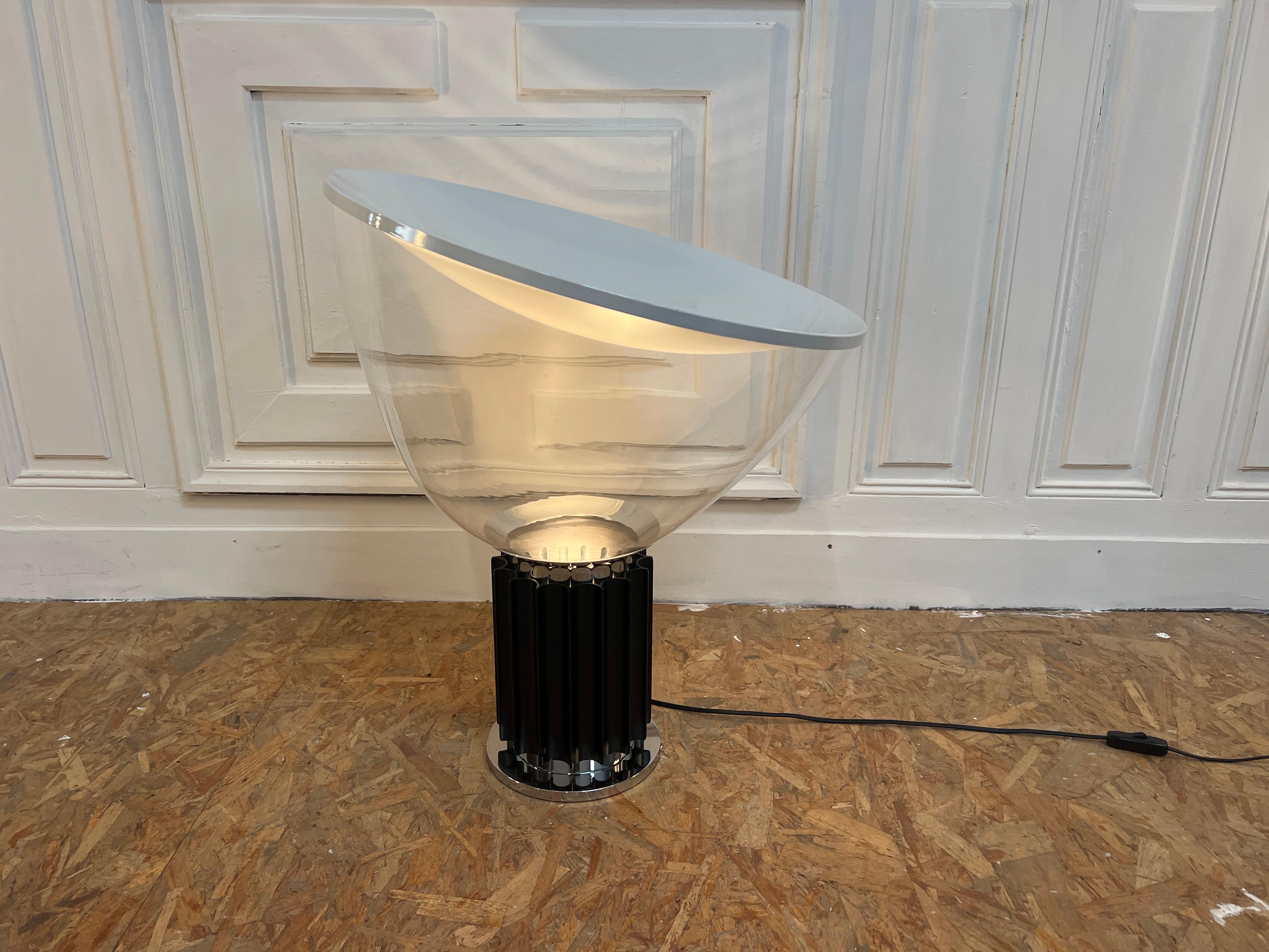 Wunderschöner Lampentisch, Modell Taccia von Flos edition 1990s 
Mit einem Murano' Glas in 50 cm (Durchmesser)

Die Leuchte Taccia wurde 1962 von den italienischen Designern Achille und Pier Giacomo Castiglioni entworfen. Sie kombiniert sehr edle