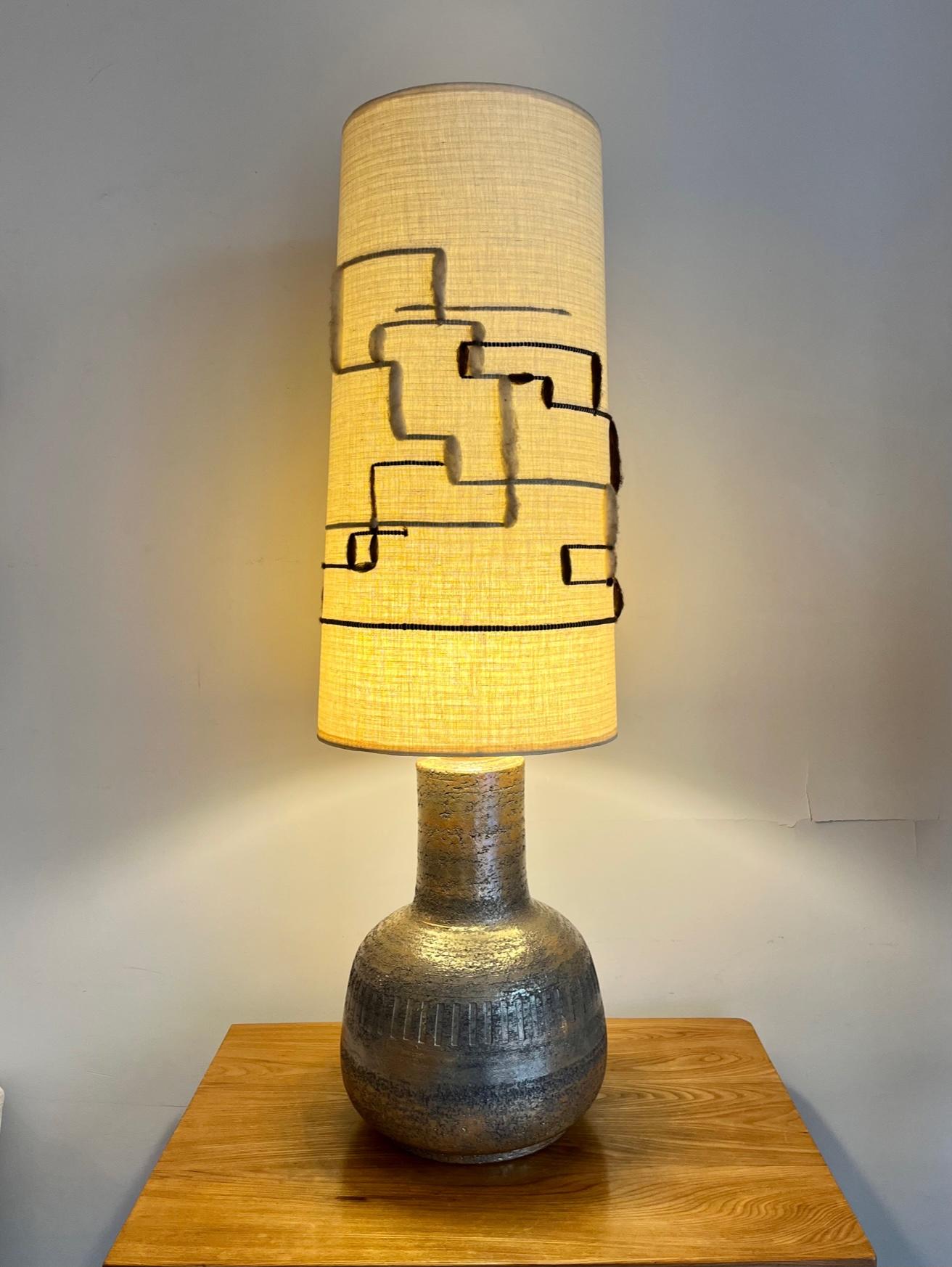 Large and high table lamp,

glazed ceramic sporting scarified  motives
Shiny metallic luster.
Original linen shade with wool linear decoration.

Can also be used as floor lamp.

By Marius Bessone ( 1929/2001 )
Vallauris, South of France circa