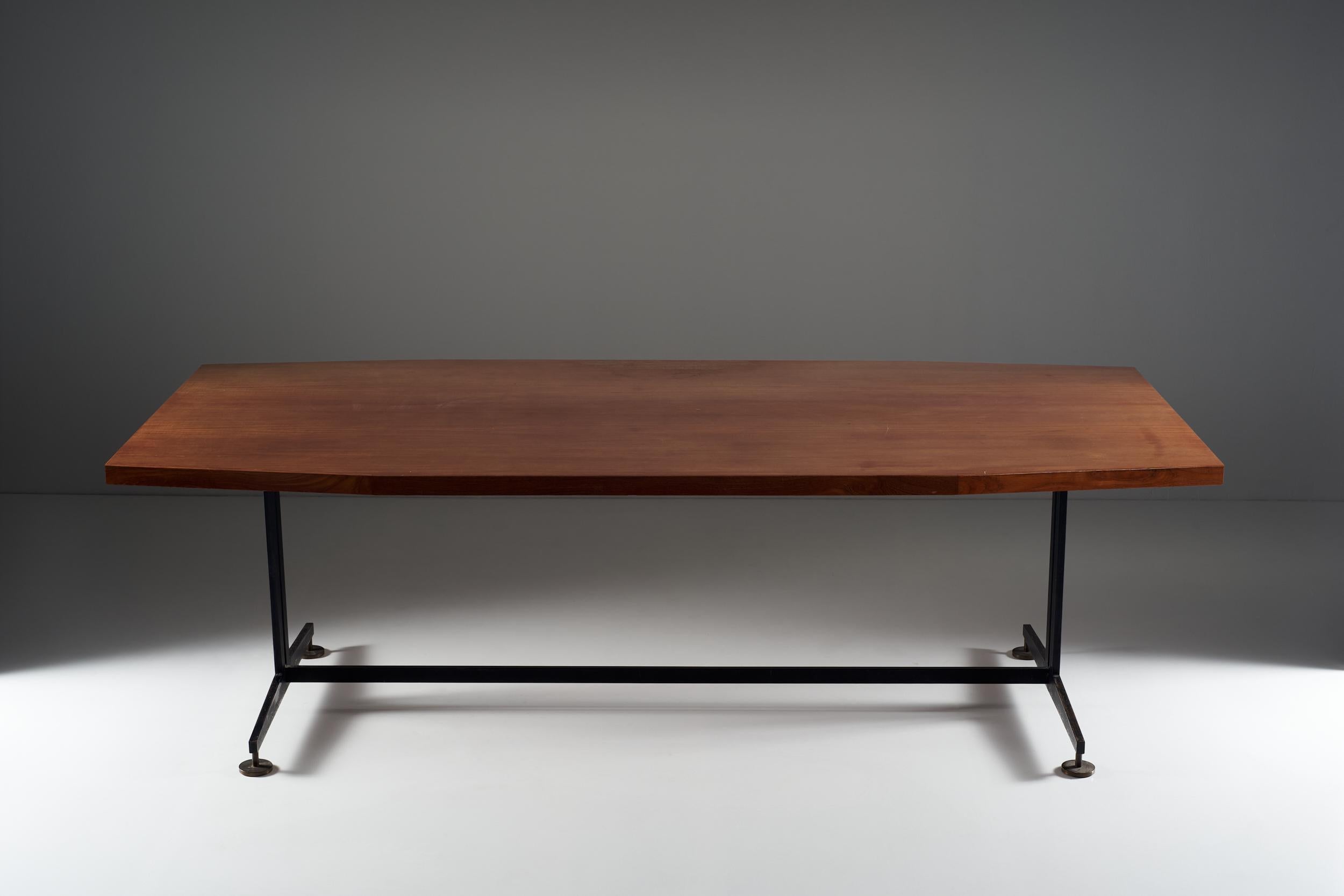 This large wooden table consists of a strong and compact top. The metal legs, lacquered in black, are built according to the lines of the wooden top. The feet form circular plates that give security and solidity to the whole structure. This Italian