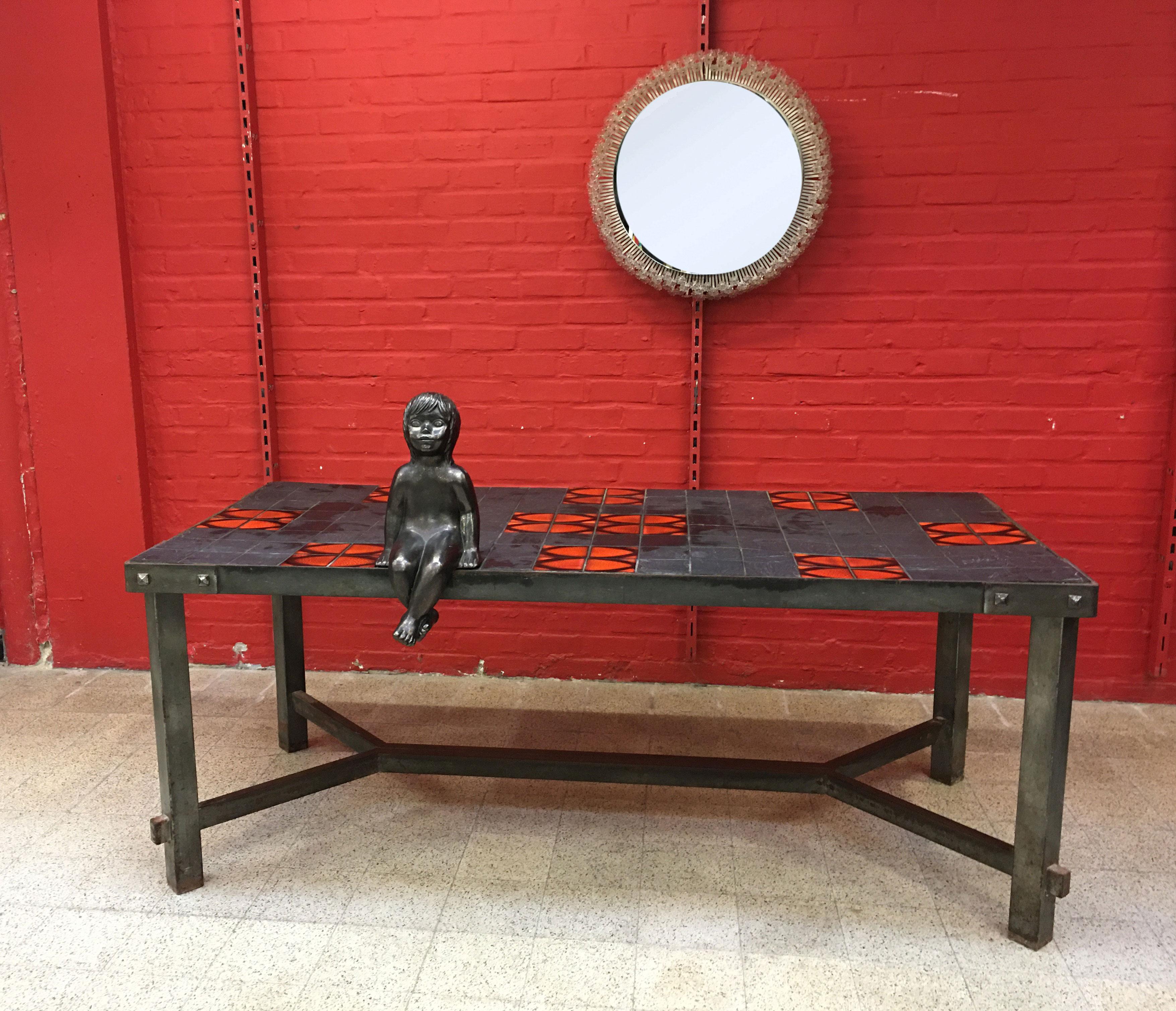 Grande table à structure métallique dans le style de Jacques Adnet, vers 1950.
Le plateau est composé de lave et de carreaux de céramique.