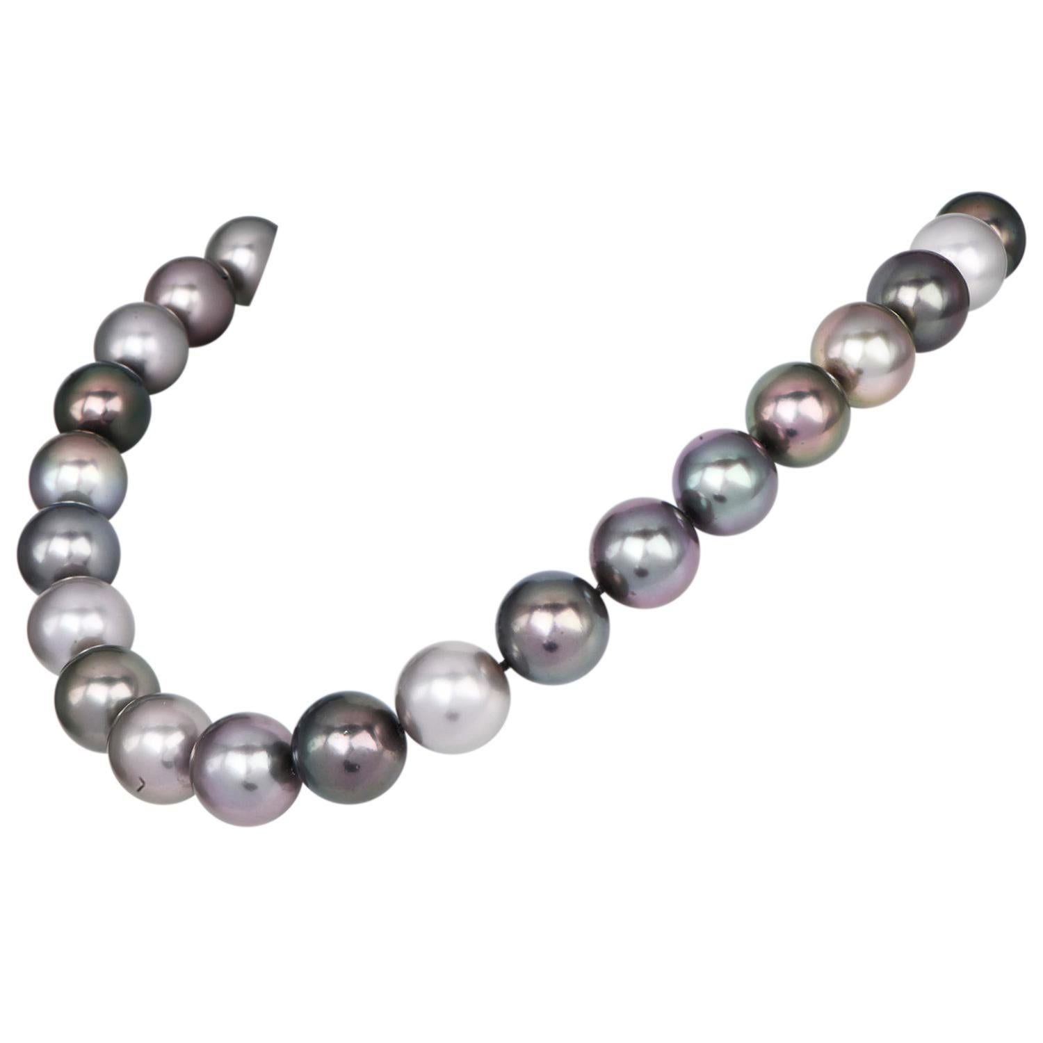 Lustrous Top-quality Tahitian Pearl necklace features a stunning array of natural, very smooth pearls in beautifully varied shades of silvery grey, with iridescent overtones. The pearls measure between 15mm -13mm, showcasing exceptional size and