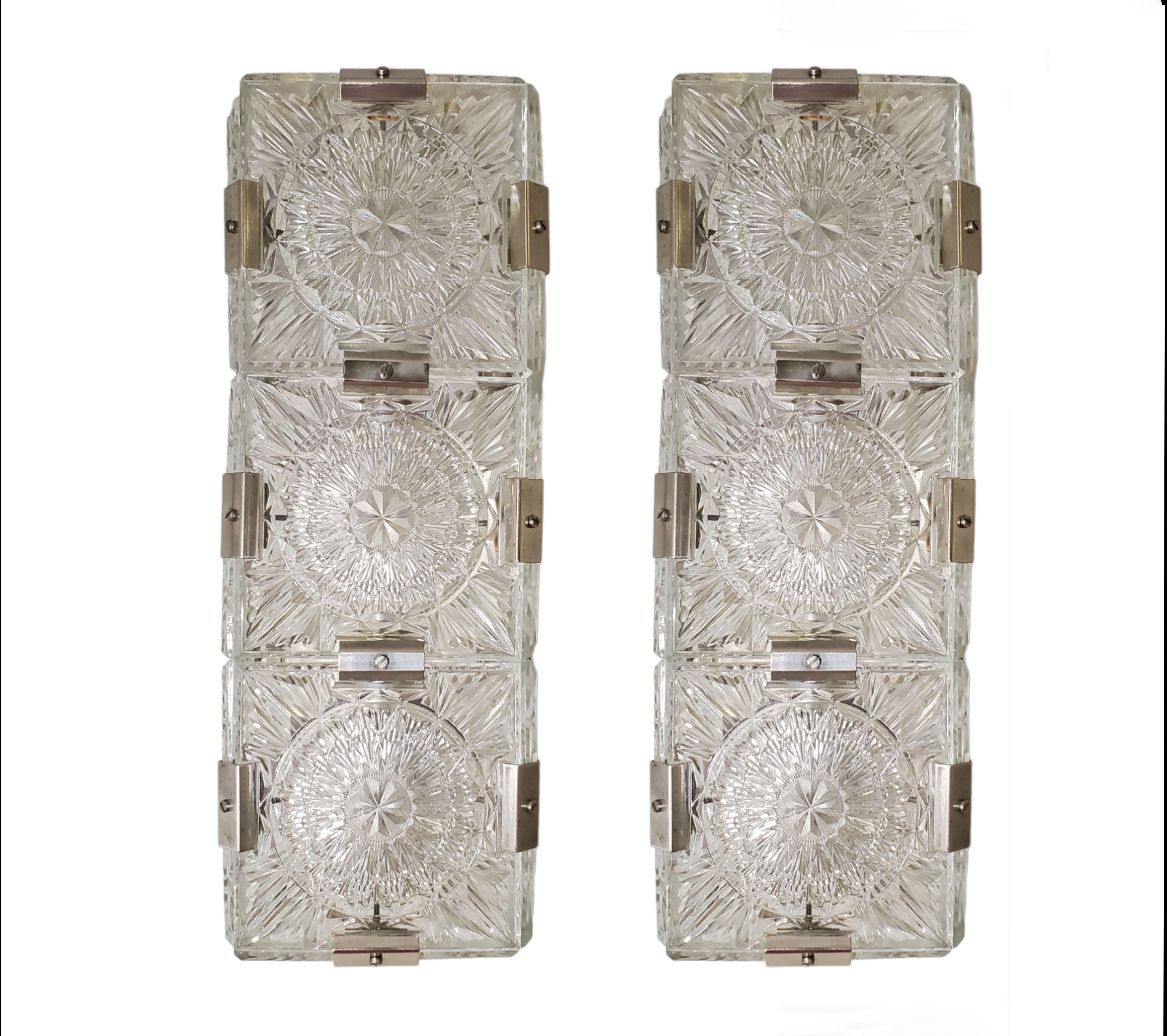 A pair of Mid-Century Modern rectangular shaped sconces.
Patterns of geometric and stylized floral motif decorate this lovely architectural sconce in a gridwork of square glass panels structurally and decoratively supported by original nickeled