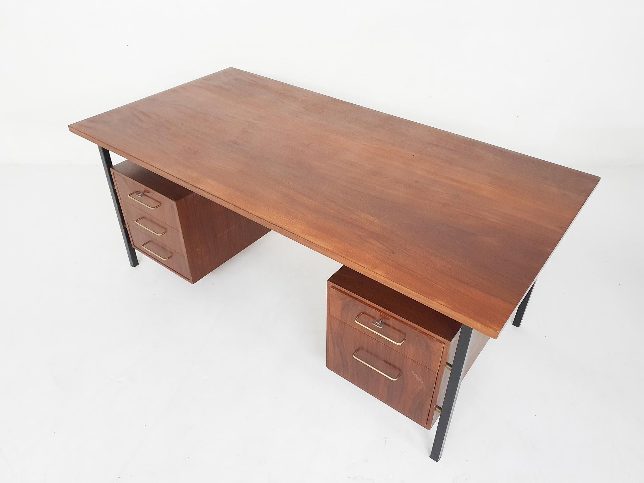 Beautiful large exuctive desk with a black metal frame and teak veneer top and drawers. The drawers have brass handles and can be locked with two original keys. 

In the style of Fristho or Pastoe.

We have sand and laquered the