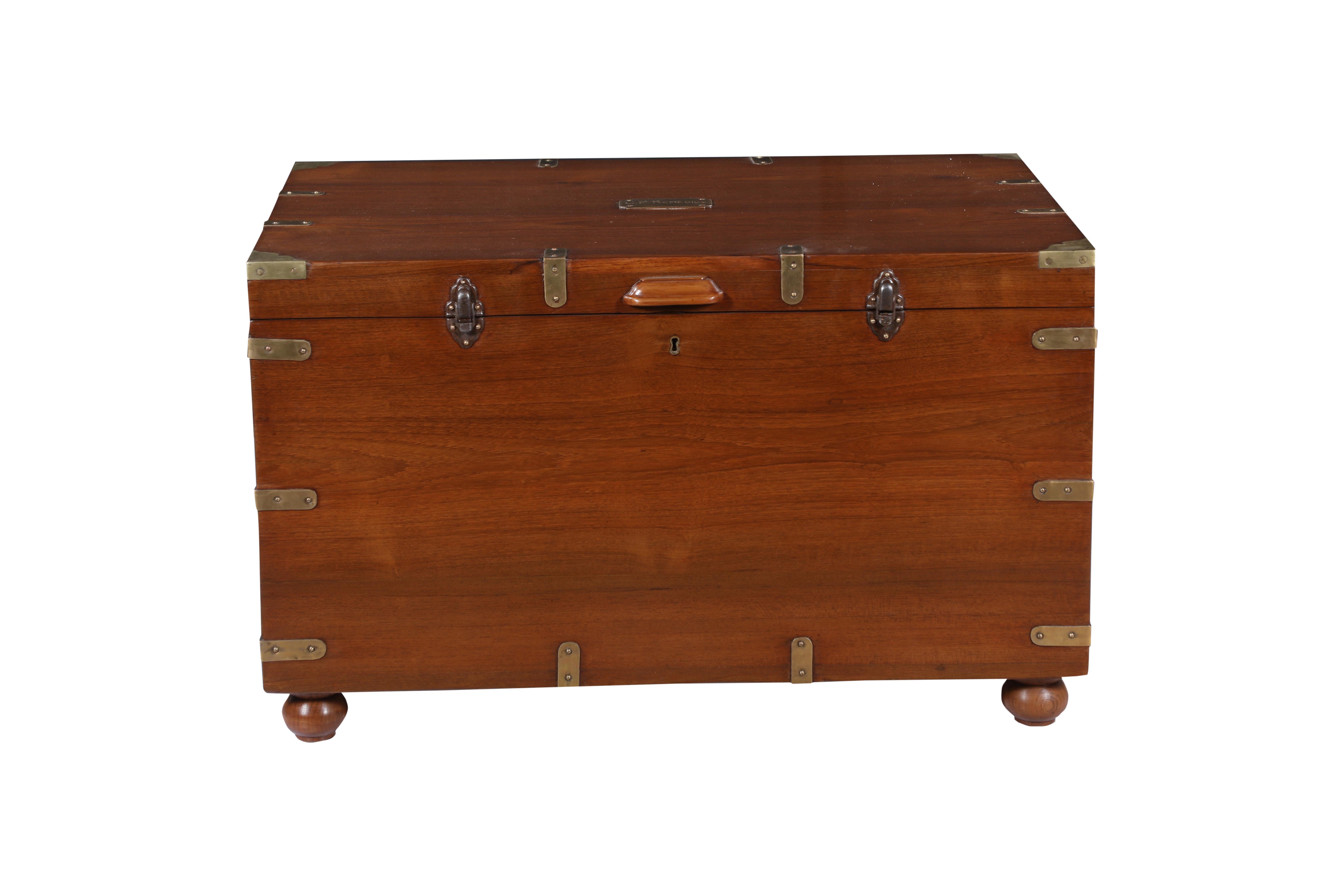 A handsome British Campaign teak blanket chest or trunk which could also be used as a coffee table. Brass straps on corners, bun feet and iron latches and handles. The interior has a tray with compartments that can lift out for further storage