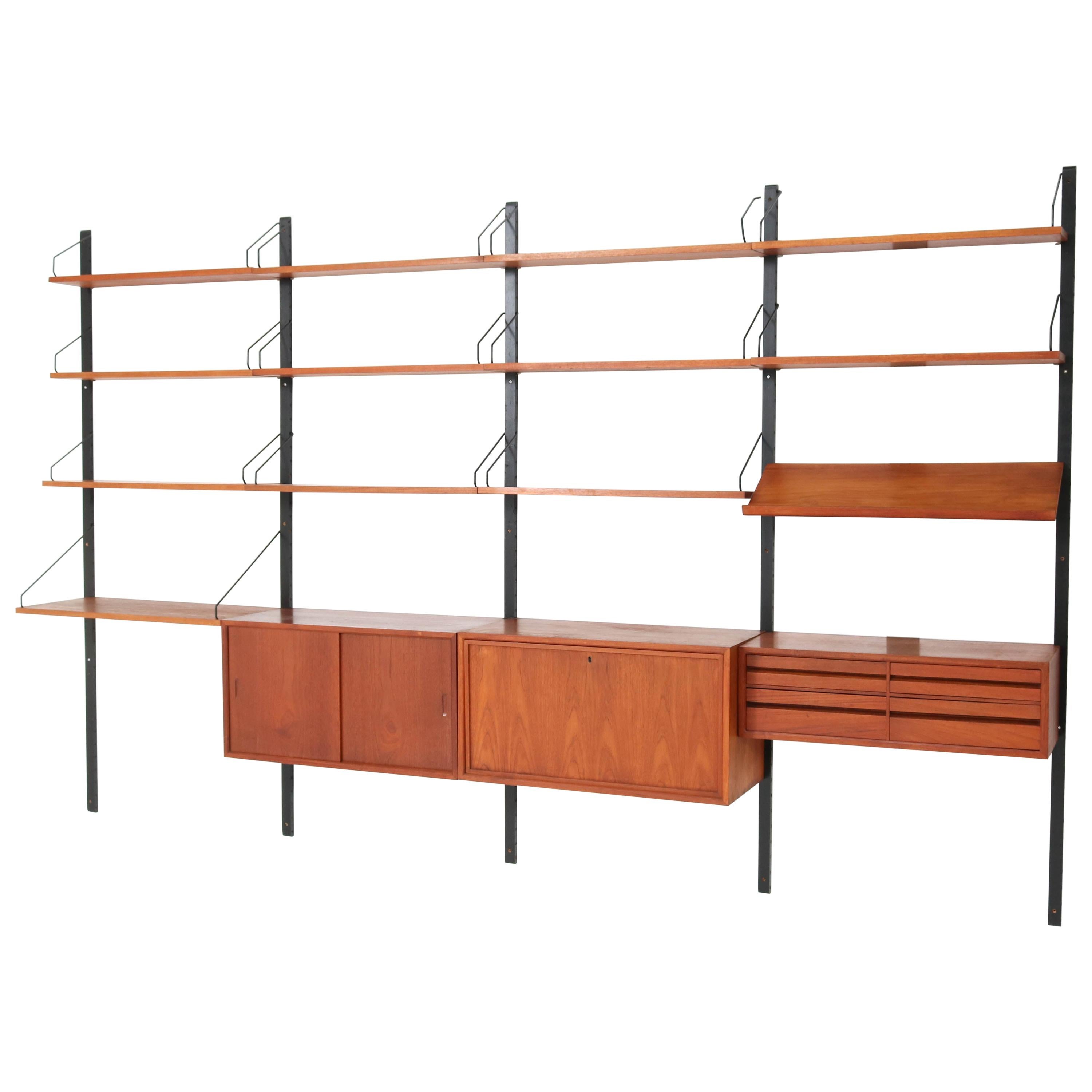 Magnificent large Mid-Century Modern teak wall unit.
Design by Poul Cadovius for Cado.
Striking Danish design from the 1950s
This wonderful wall unit with hard to find magazine shelf consists of
5 black lacquered wooden uprights H 202 cm or