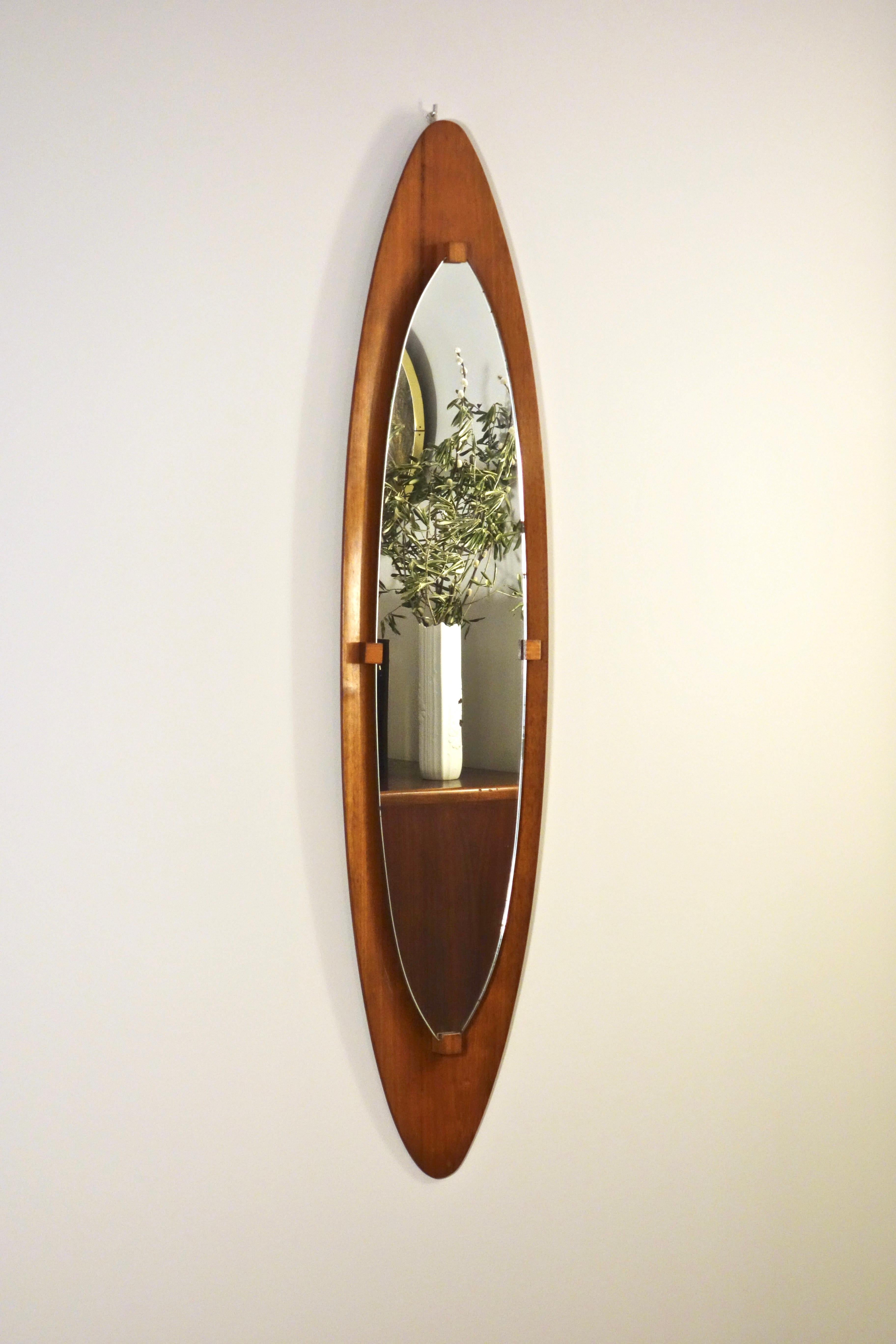 Grand miroir italien des designers Franco Campo & Carlo Graffi pour Home datant des années 1950

Miroir mural de forme ovale avec entourage cintré en teck contreplaqué recevant un miroir maintenu par 4 pièces de teck massif.

Objet restauré avec une