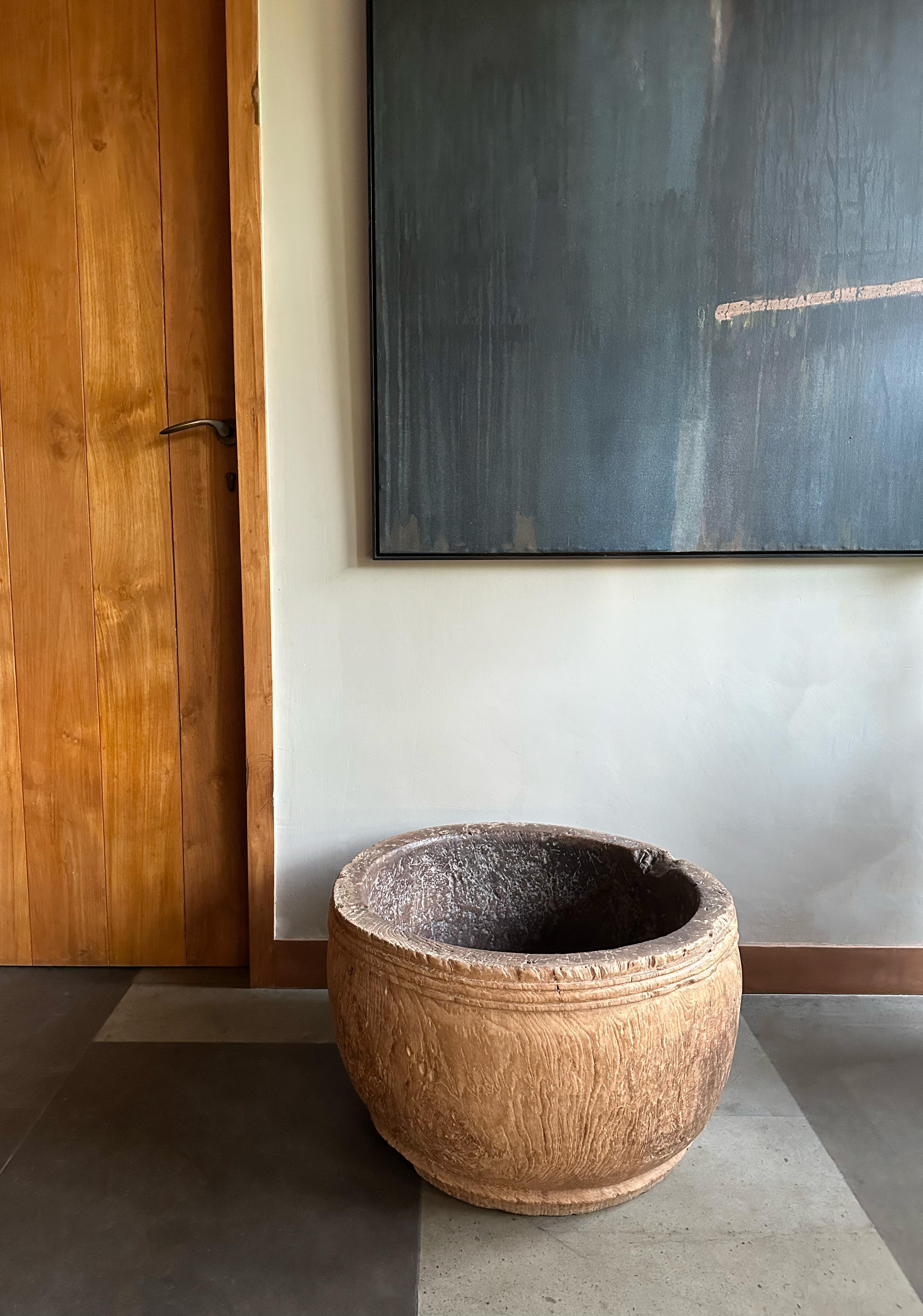 A large teak wood bowl crafted on the island of Java, Indonesia. The bowl was cut from a much larger slab of teak wood and maintains an organic shape and natural textures. The subtle carved detailing that runs the circumference of the bowl adds to