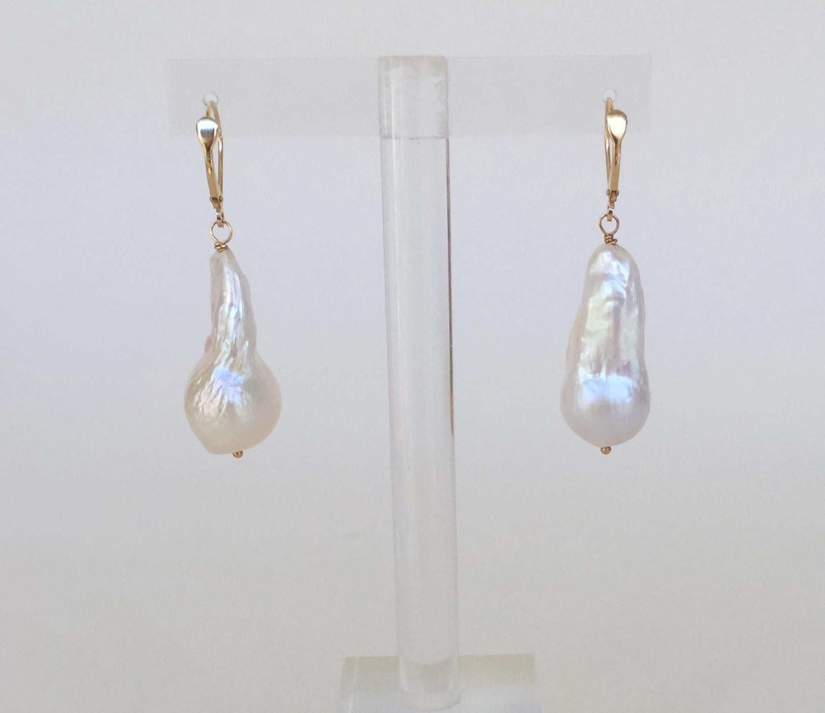 These large tear baroque white pearl drop earrings with 14k yellow gold lever backs are eye-catching and luxurious. With large baroque white pearls, these earrings are a re-invention of the classic drop pearl earrings. These earrings are completed