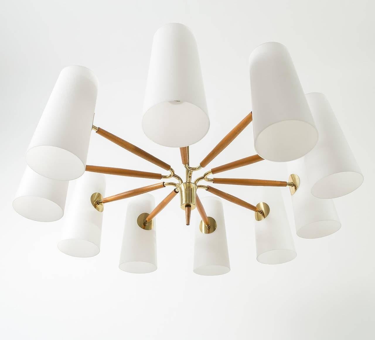 Un bellissimo e grande lampadario a dieci bracci di Rupert Nikoll, Vienna, prodotto nel Mid-Century, circa 1960 (fine anni '50 o inizio anni '60). 
Un bel mix di materiali: grandi paralumi in vetro opalino/latte, ottone e caldo legno di faggio.