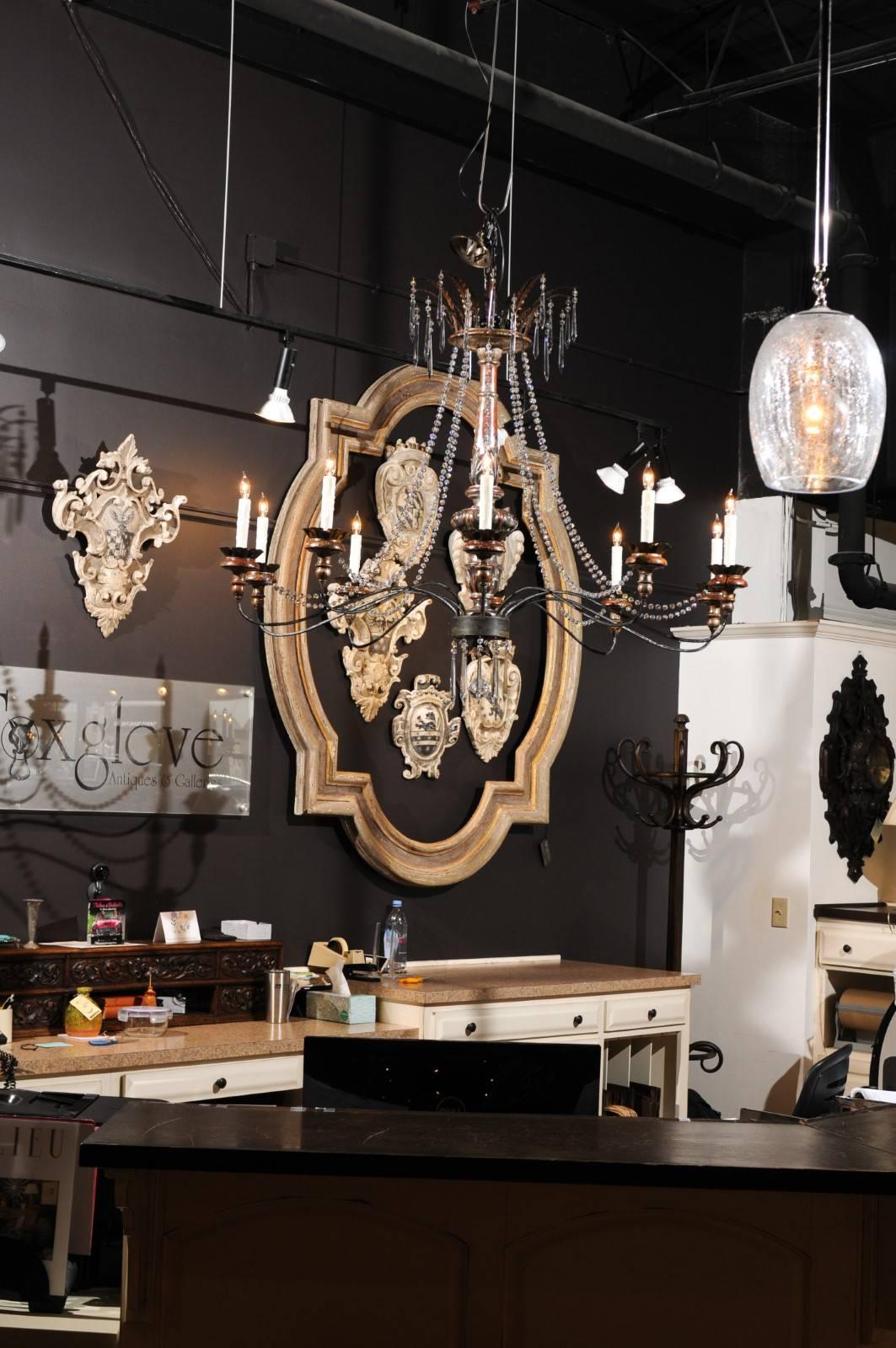 A large contemporary ten-light carved wood and crystal chandelier made of 19th century Italian parts and wired for the US. This exquisite newly made ten-light chandelier features a 19th century painted and carved Italian pricket, serving as the