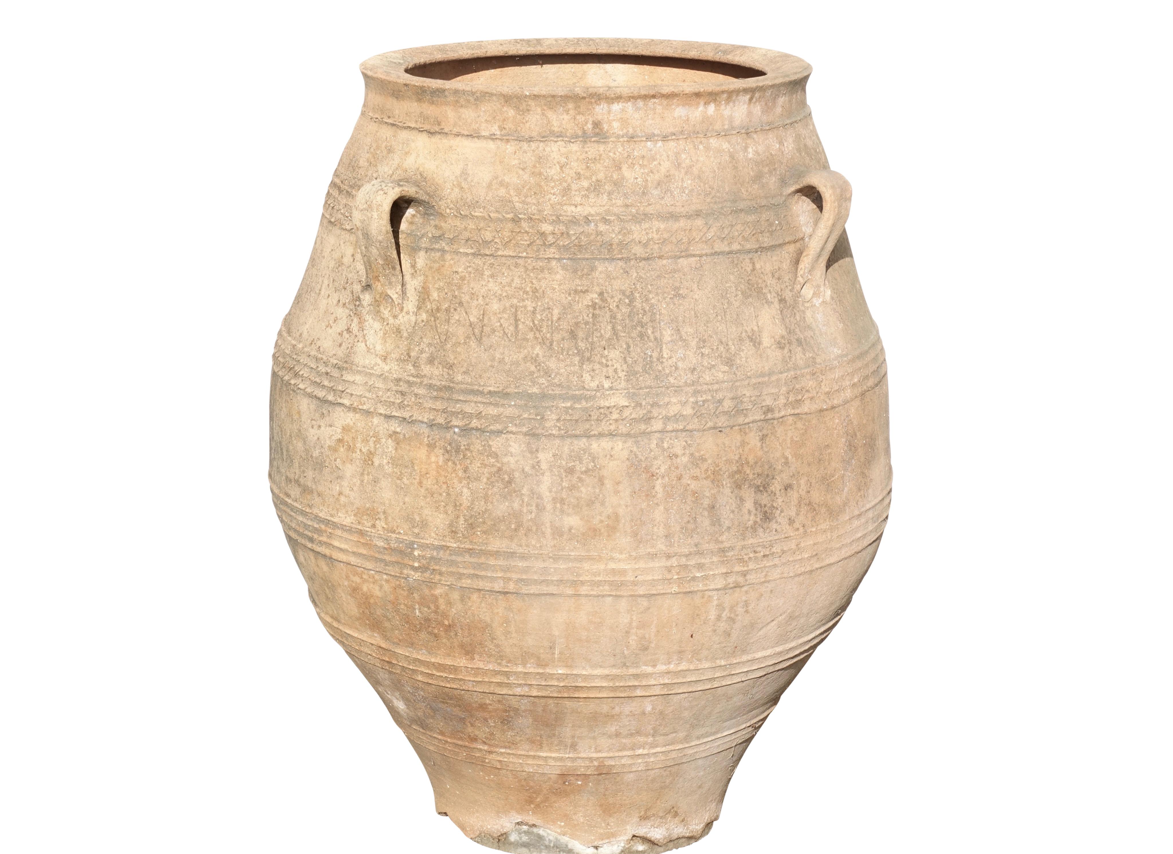 A large terracotta oil jar of ovoid shape with bands of ribbing and three loop handles. Some restoration to the base of the jar. Italian, 19th century.