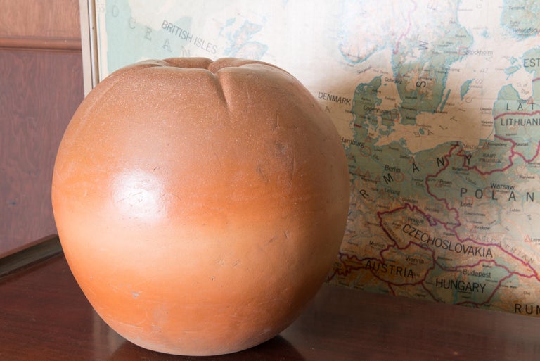 Decorative terra cotta fruit. It appears to be a peach. Hand crafted.