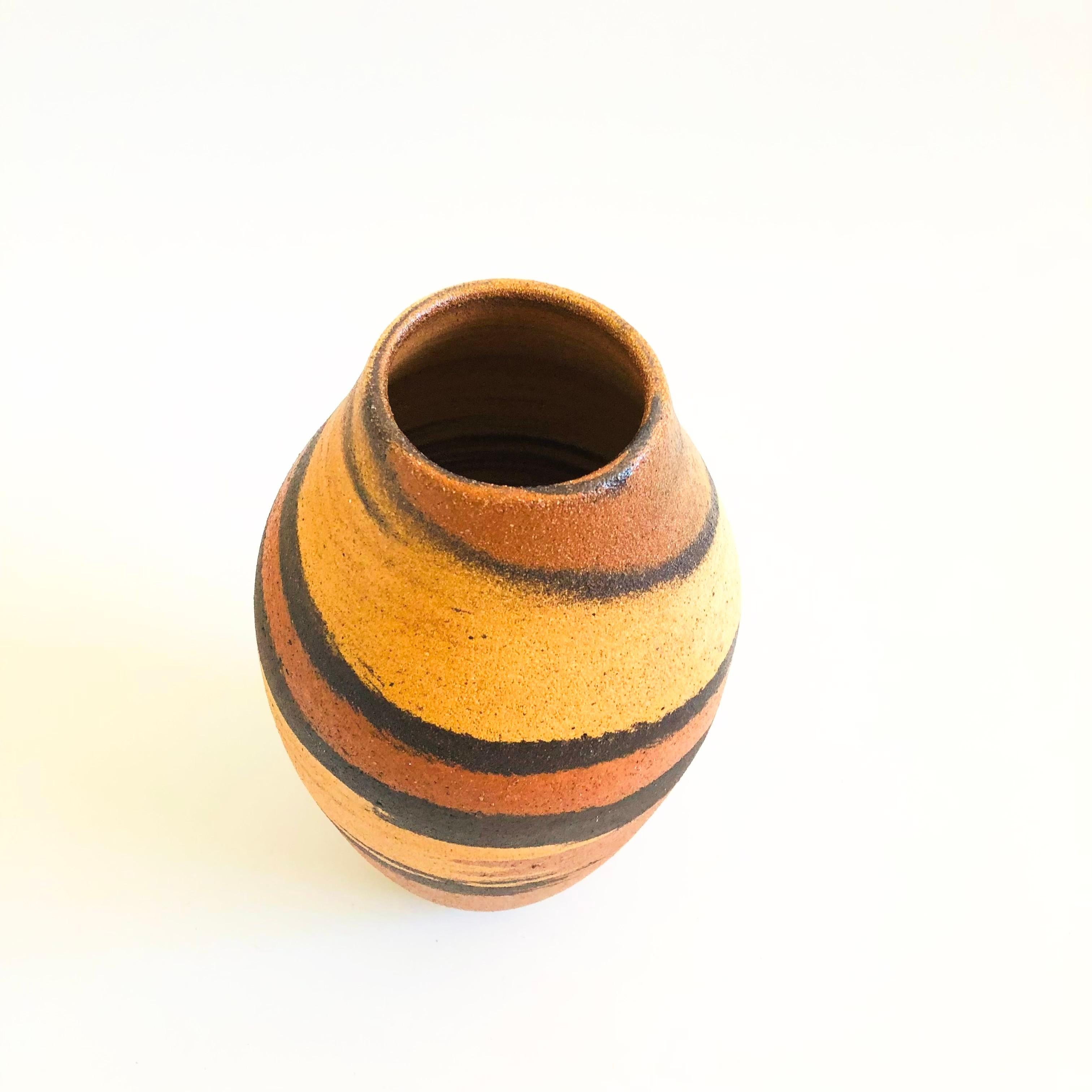 A tall vintage pottery vase. Lovely organic swirl design in natural colors. Felted on the base. Nice versatile larger size.

