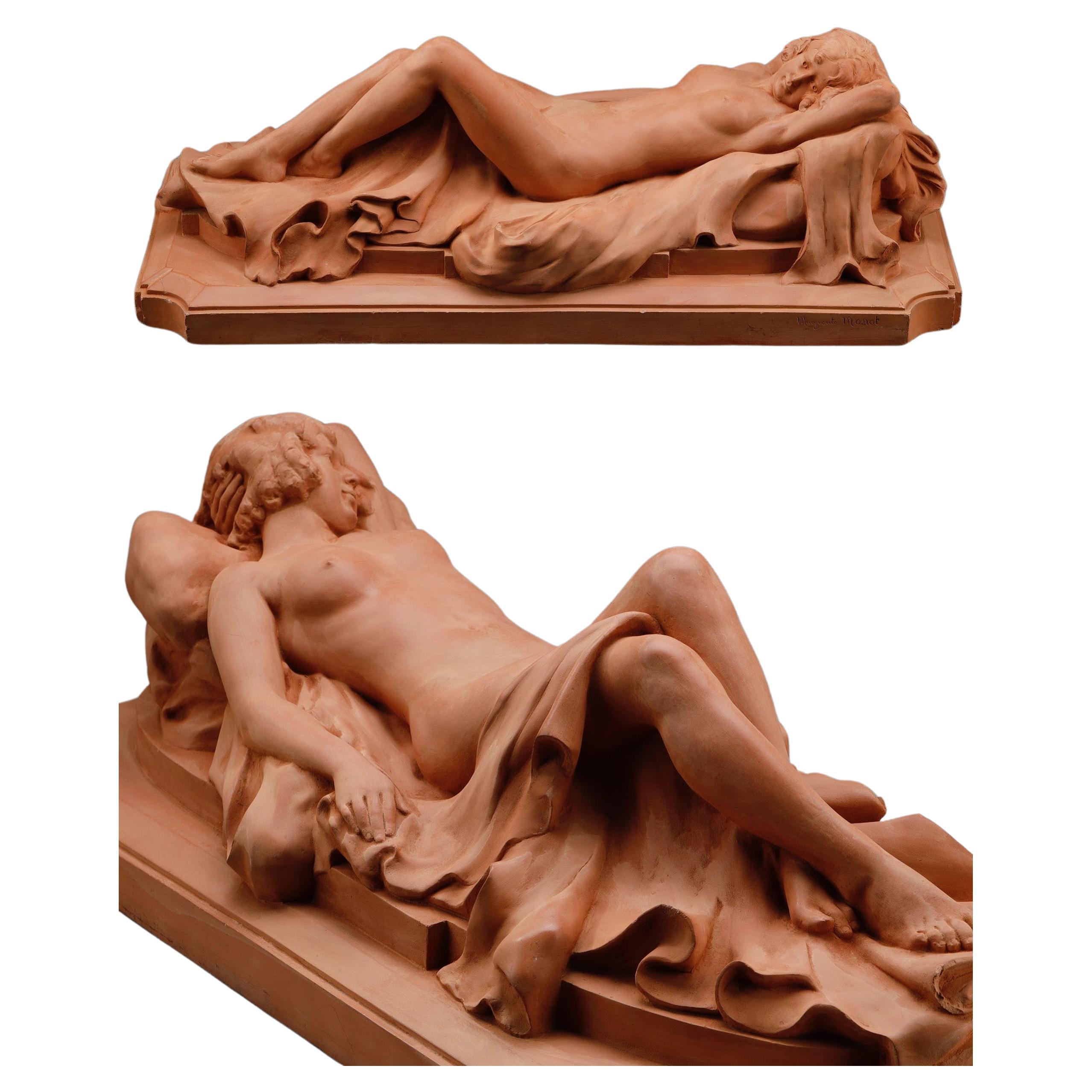 Large terracotta sculpture depicting an Odalisque reclining on a drape