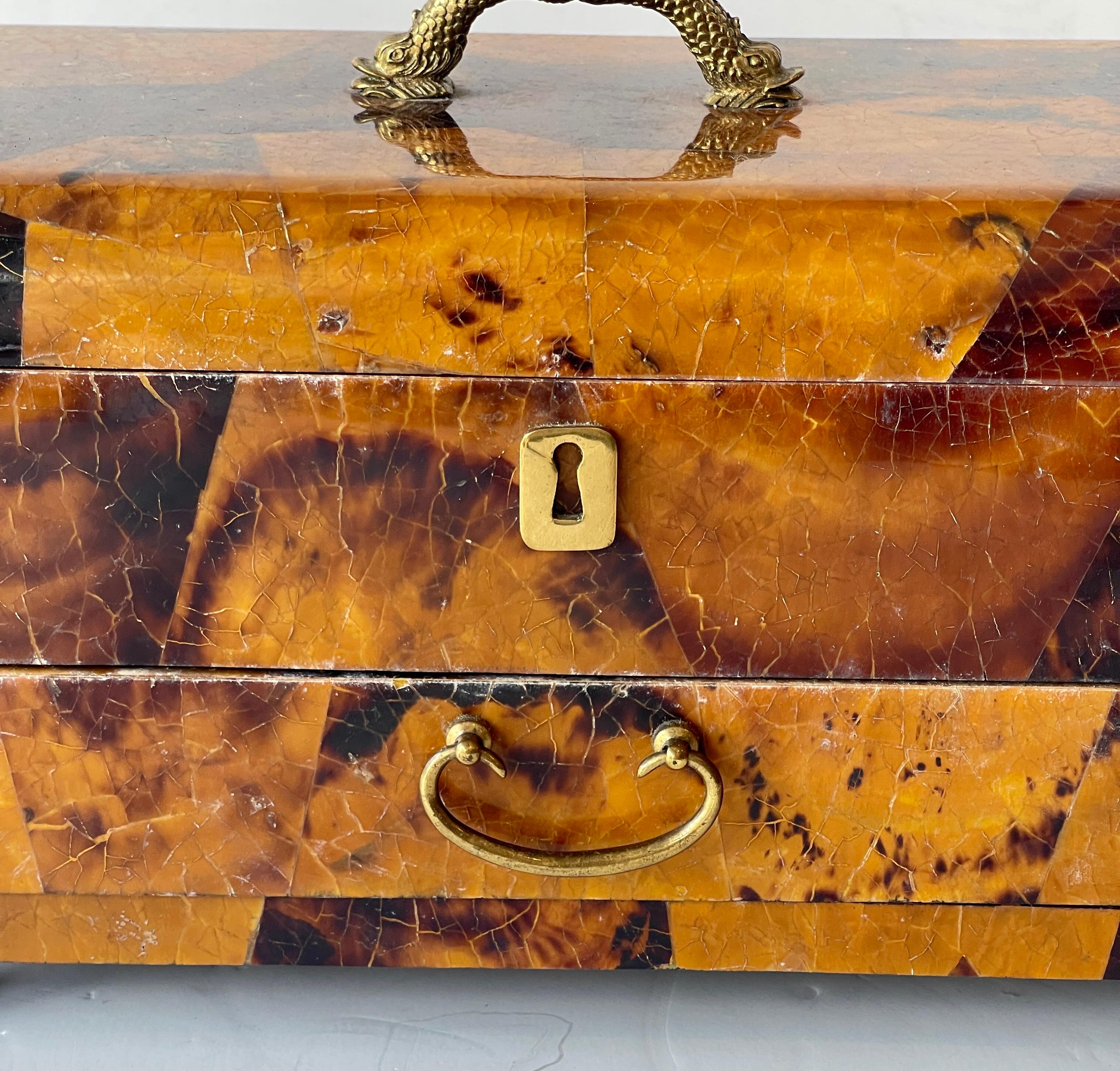 This is a great looking Large Tessellated Pen-shell Jewelry Box, Attributed to Maitland Smith.
This large jewelry box has a drawer and an upper compartment. A beautiful double dolphin  brass Handle and stands on for Brass detailed ball feet.
Very