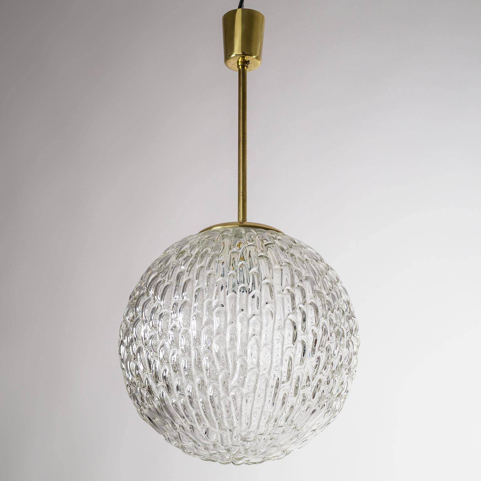 Beautiful Austrian mid-century globe pendant with a very uniquely textured crystal glass body which has an organic, almost liquid feel about it. Fabulous display of light when lit. Very good original condition with a bit of patina on the brass. One