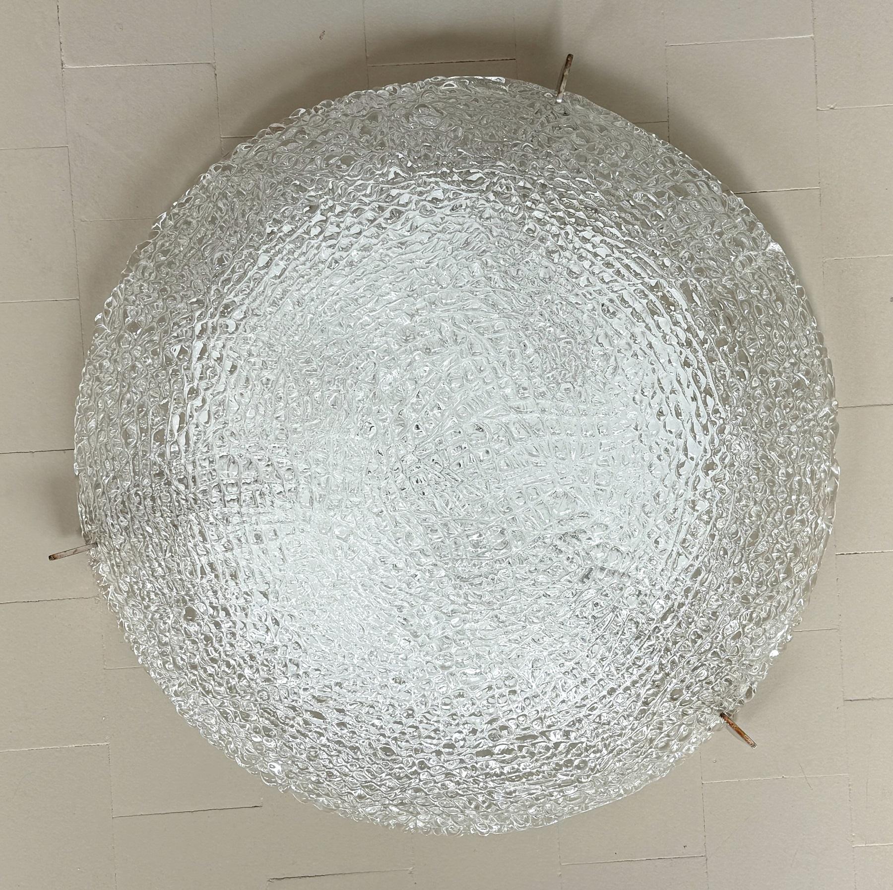 A large textured ice glass flush mount light fixture by Kaiser Leuchten, Germany, manufactured during the mid-century, circa 1960. The flush mount comes with the original label.
Much better in person than on the pictures.
The backplate in white