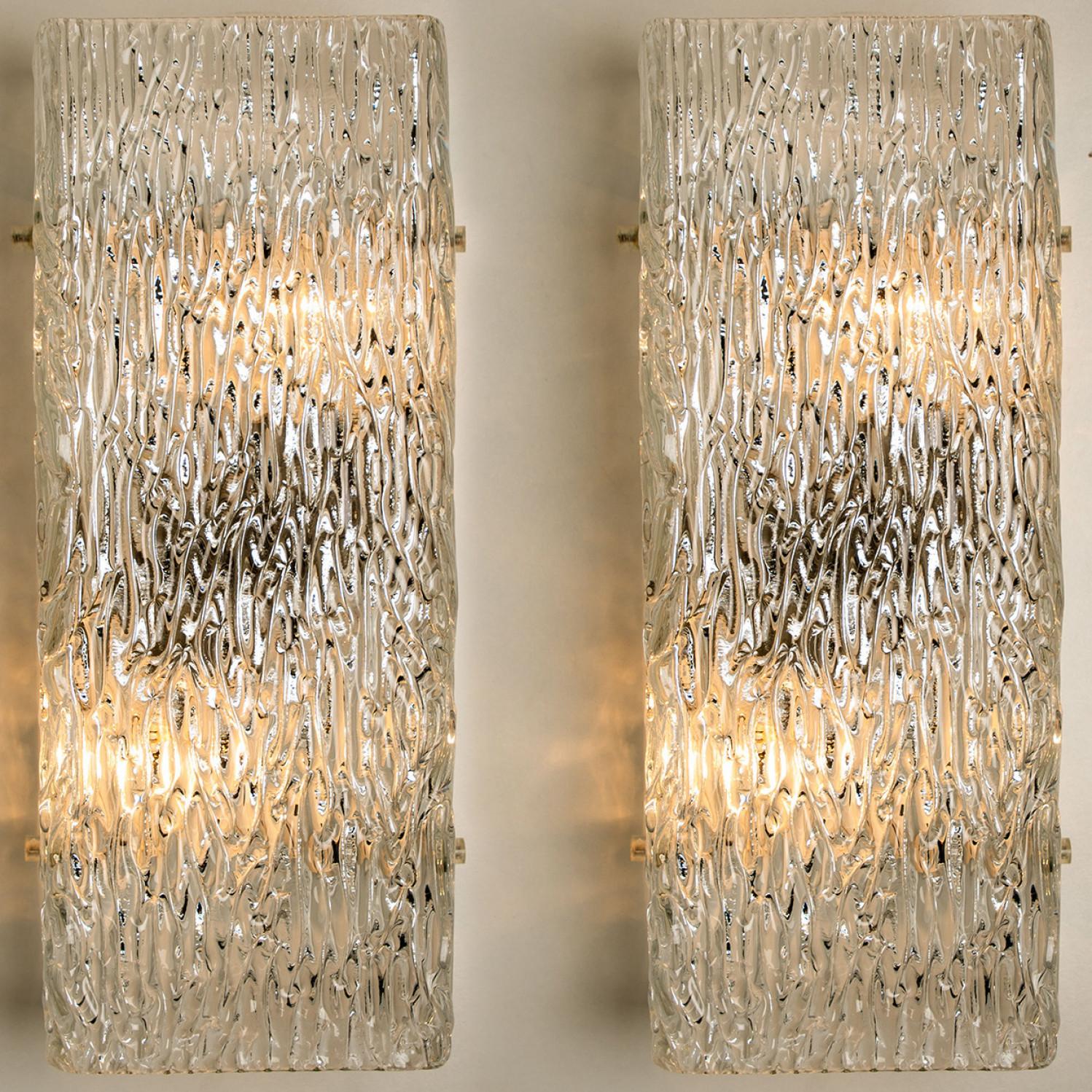 Eine der beiden Beleuchtungskörper von J.T. Kalmar, Wien, Österreich, hergestellt ca. 1960. Das Glas weist eine schöne Wellenstruktur auf, die einen diffusen Lichteffekt und ein schönes Muster an Decke, Wänden und Boden erzeugt.
Die stilvolle