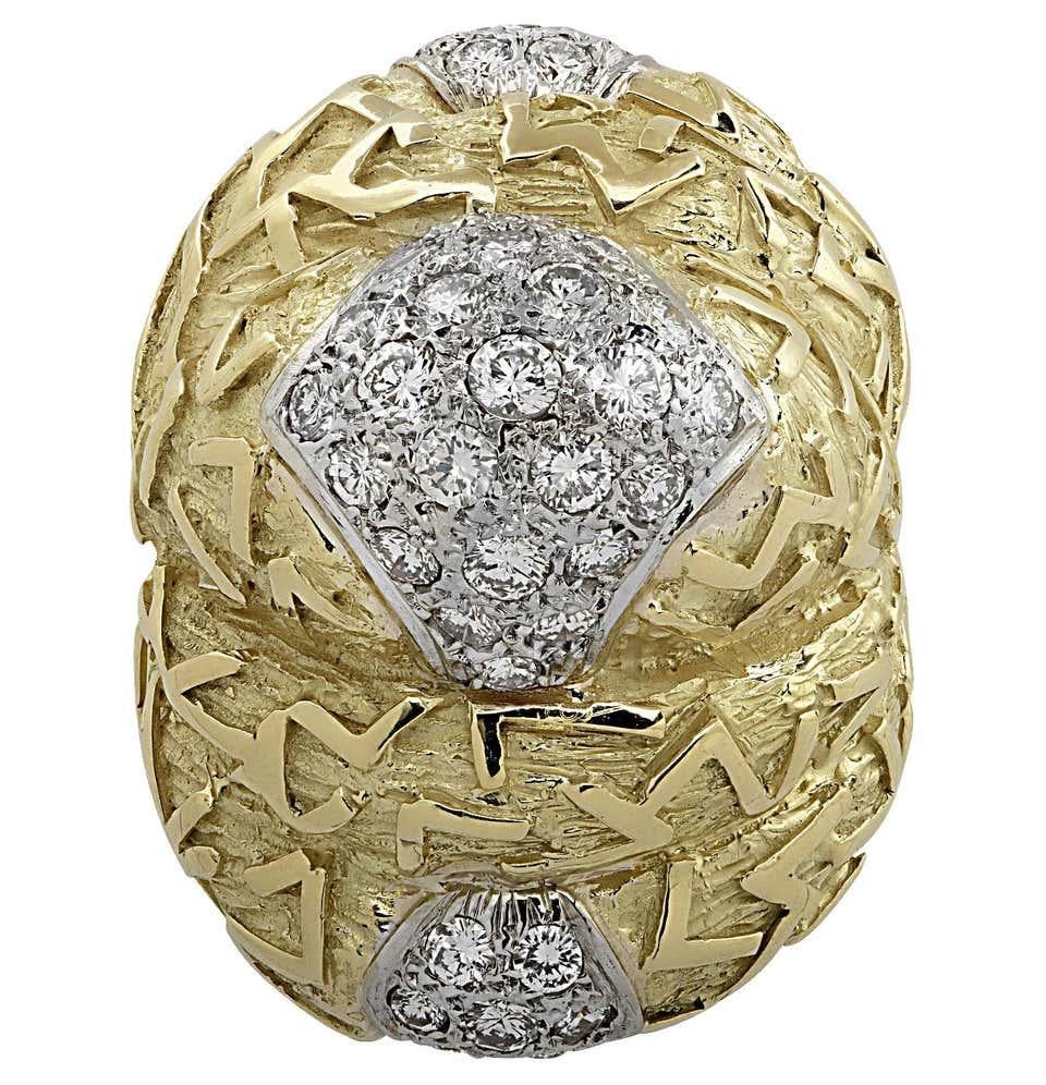 A powerful cocktail ring featuring a textured 18 karat yellow gold motif, embellished with 2.5 carats of diamonds. Circa 1970.