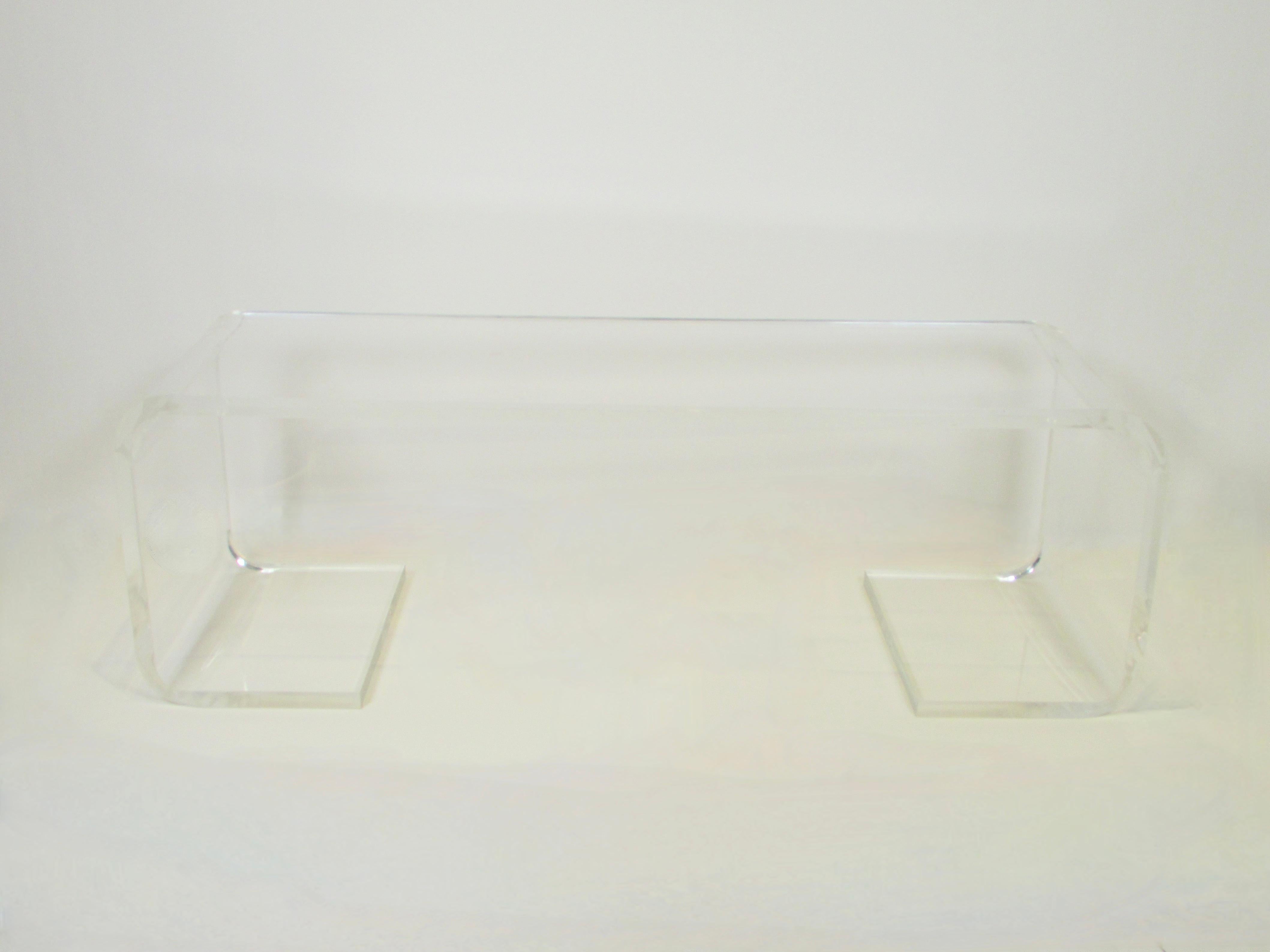 Large one inch thick lucite bench or coffee table . Flat slab top rolls down either side and along the floor . Recently polished very little if any evidence of scratching no nicks . Cleanest piece of Lucite I have had in a long time .  Images really