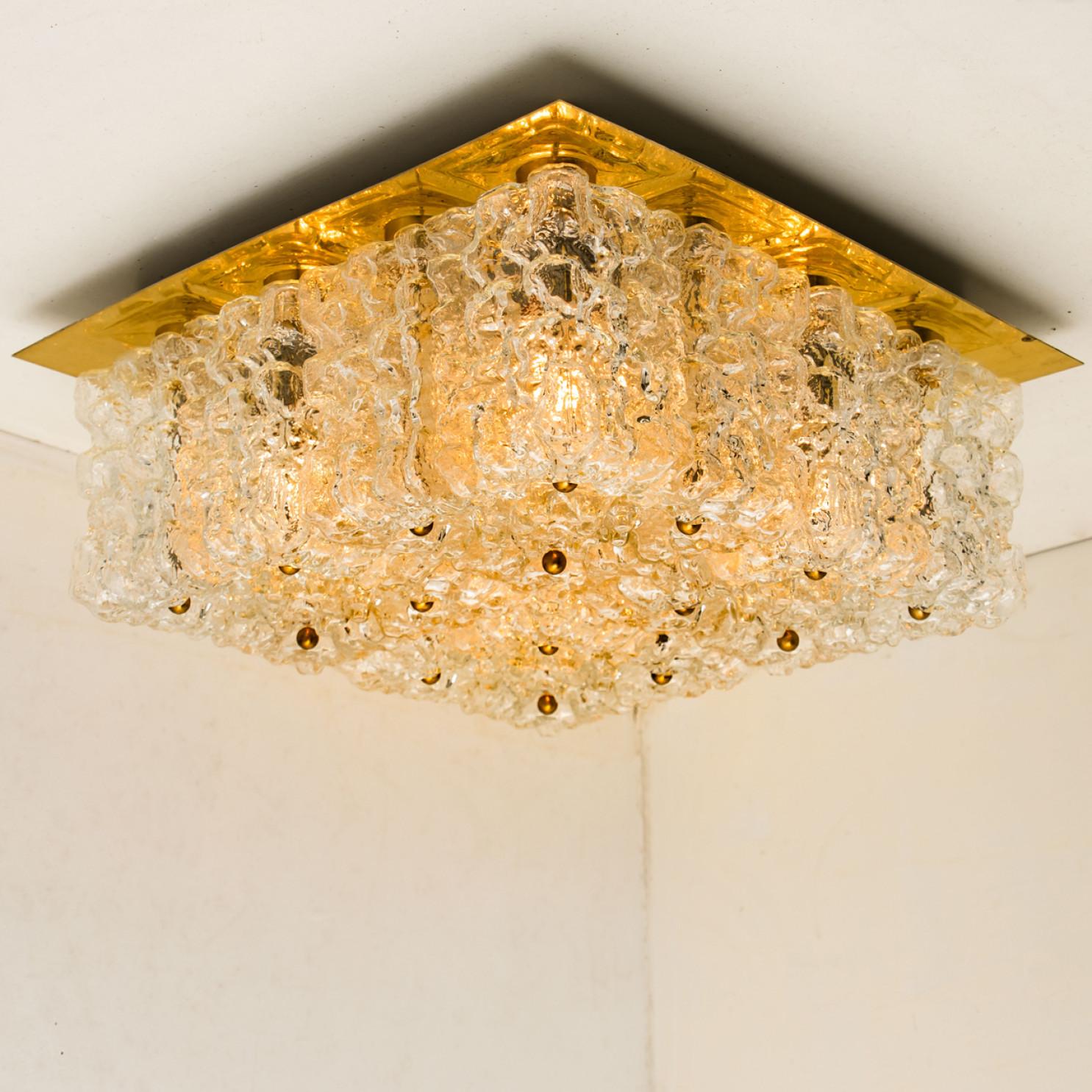 Mid-Century Modern textured ice glass light fixture by German manufacturer Kaiser, circa 1965.

This ceiling light, often mistakenly attributed to Kalmar, features 16 glass blocks mounted on a golden brass backplate.

Well- wired, cleaned in full