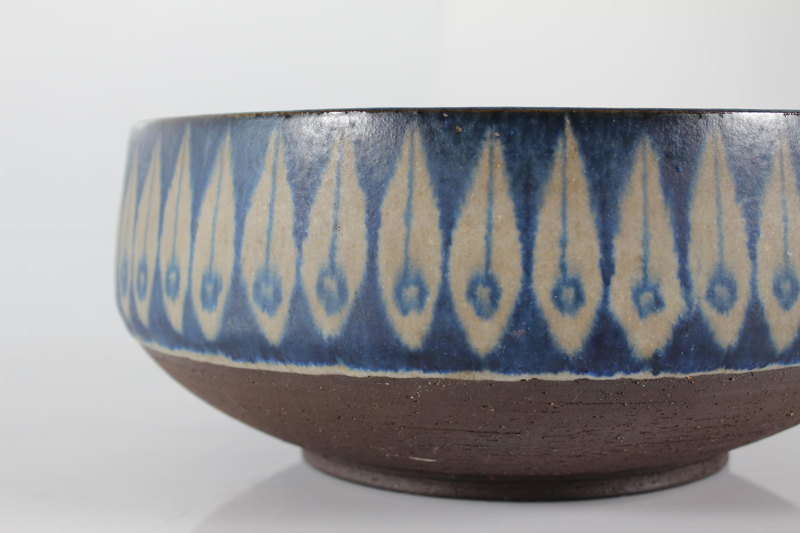 Große Keramikschüssel aus Schamotte-Ton, von Hand verziert mit einem Blattmuster. 
Glasiert mit seidenmatter grauer und kobaltblauer Glasur. 
Der äußere untere Teil bleibt unglasiert.
Hergestellt in seiner eigenen Keramikwerkstatt in Bisserup auf