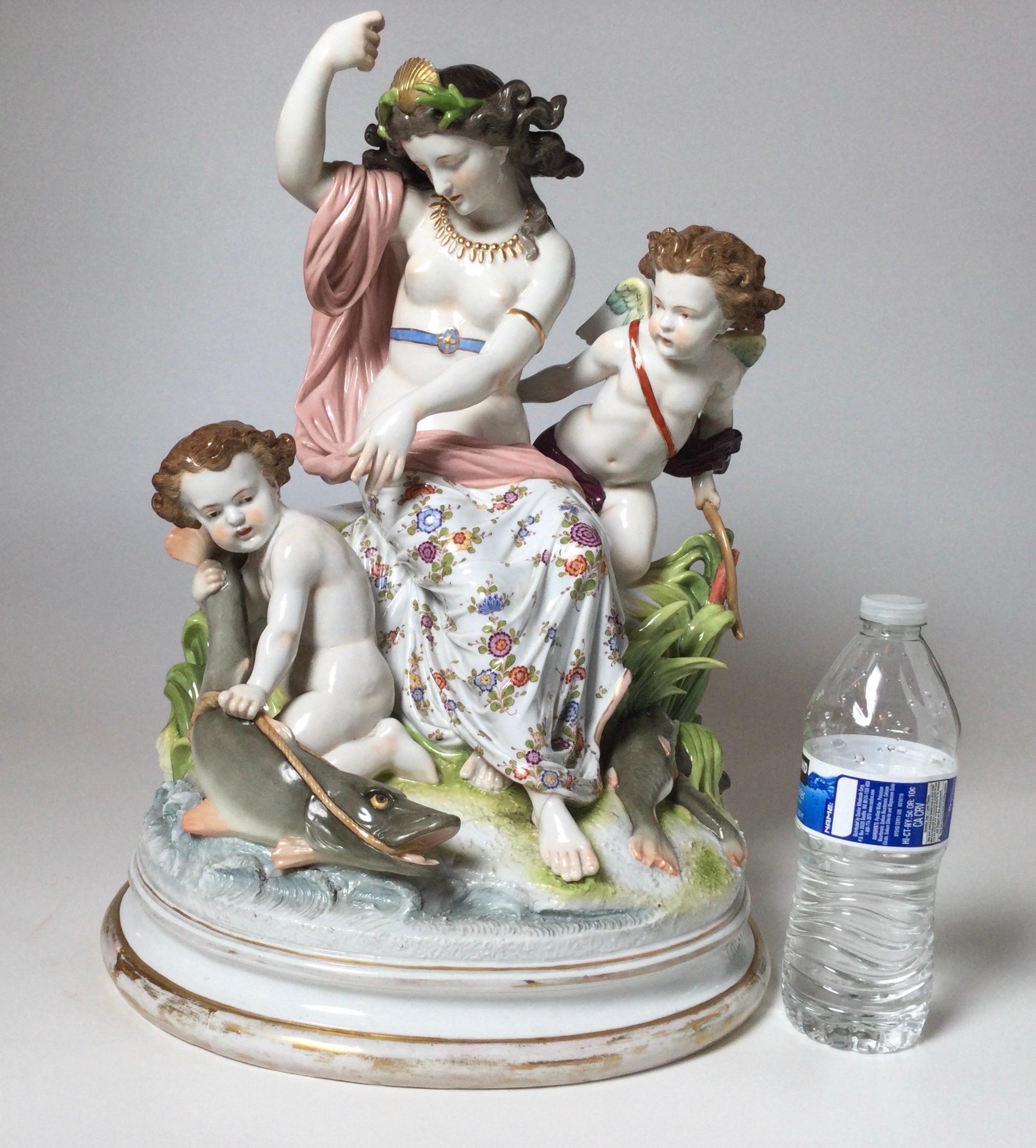 A stunning hand painted figural porcelain grouping of a maiden with two putti with fish. by artist Theodore Herbert, 1868. the oval piece with plinth base showing age appropriate wear tot he gilt at bottom. The piece is in remarkable condition with
