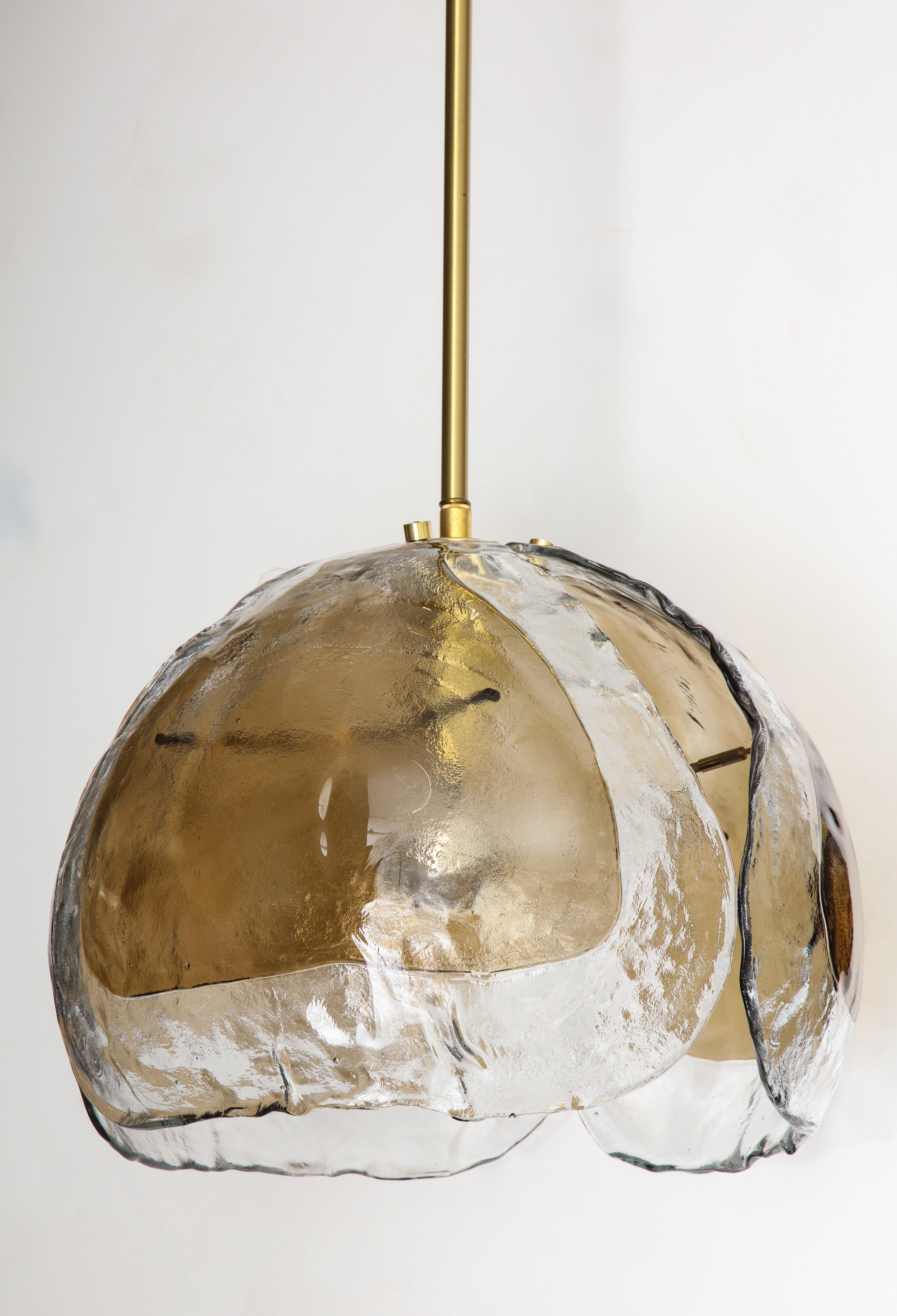 Large midcentury Murano glass pendant light by Mazzega.
The three clear and smoky glass elements come together to form a bowl shape. This is suspended by a brass rod and canopy which can be customized to your desired length.
The fixture has been