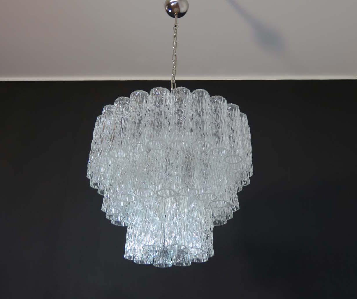 
Lustre vintage italien en verre de Murano et structure en métal nickelé. L'armature en nikel poli supporte 52 grands tubes en verre clair légèrement texturés pour créer un impressionnant lustre à effet 