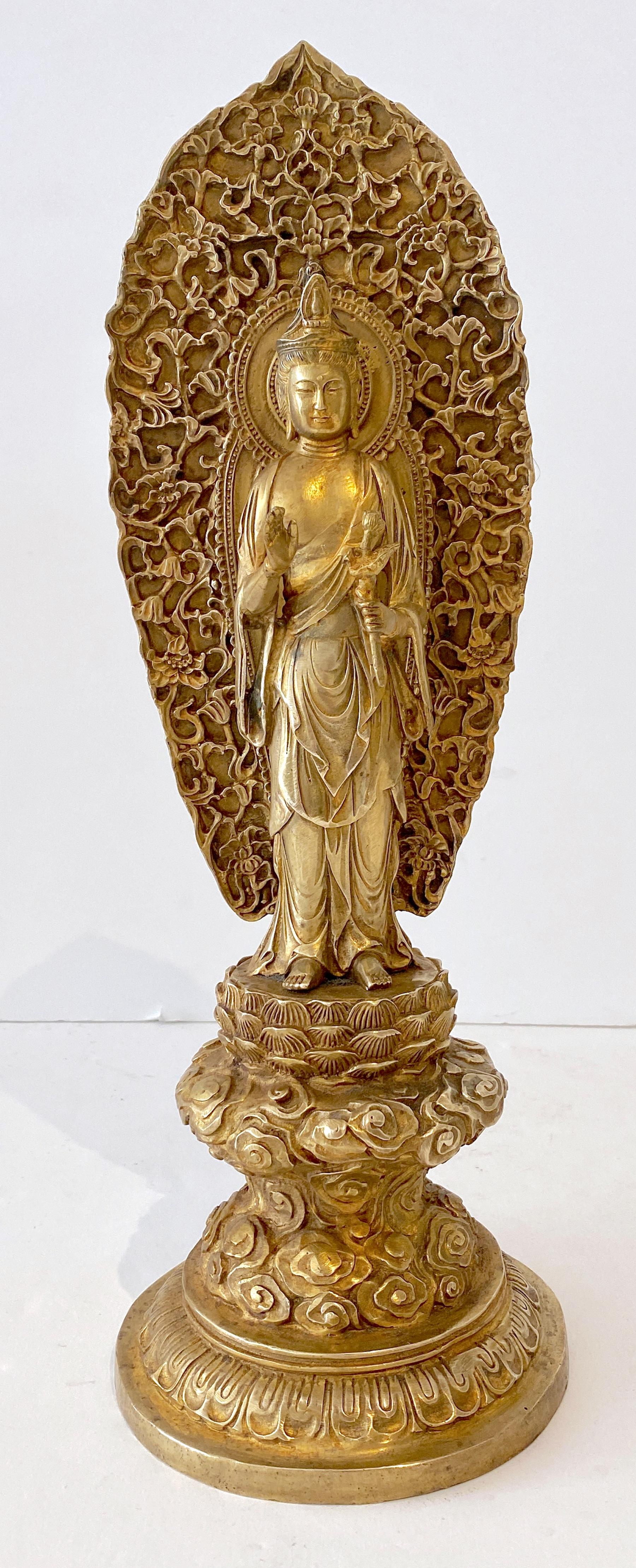 Large Tibetan Gilt Bronze Standing Buddha with Halo  
China, 20th century 
The slender figure is finely cast and shown standing the right hand is raised in abhayamudra, and the left holding a branch. Surrounded by a large and elaborate halo. 
Marked