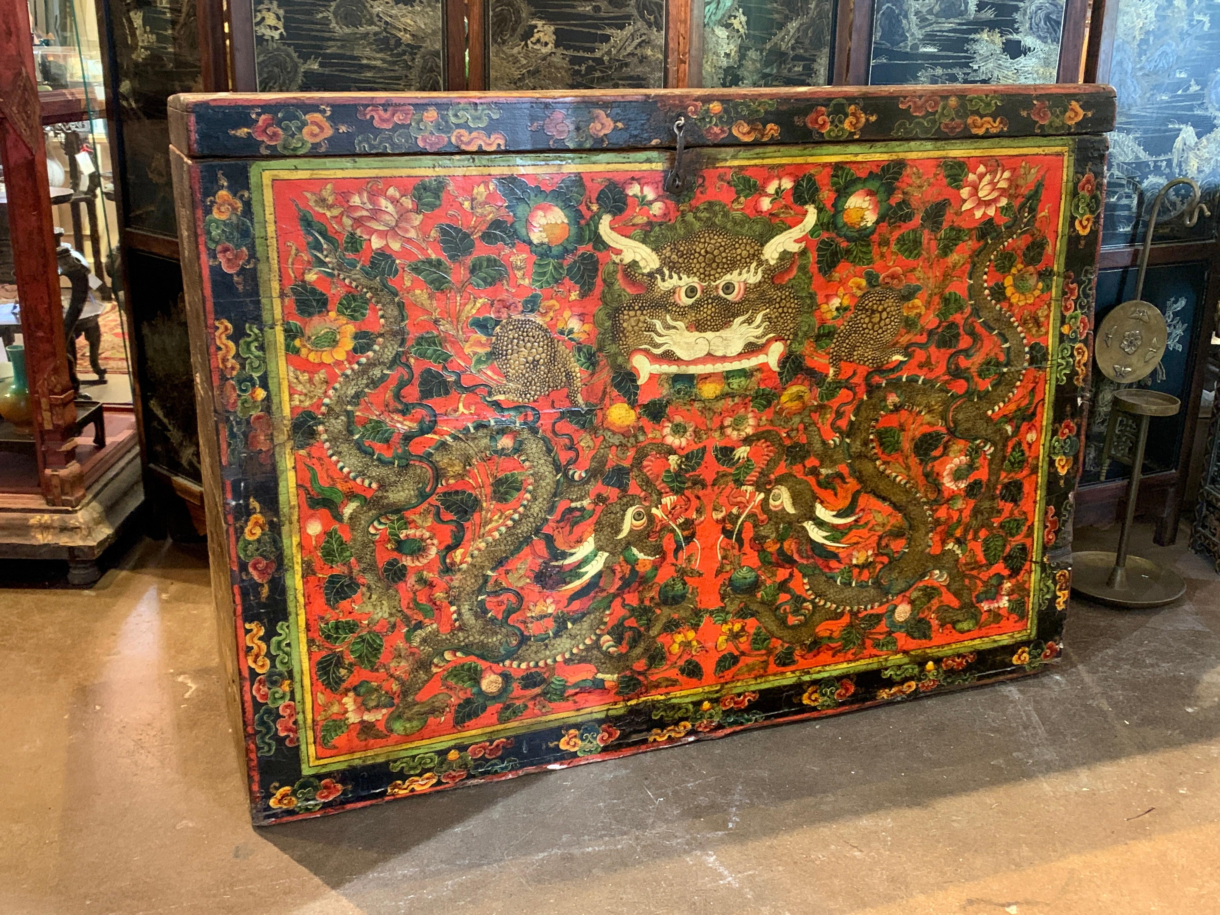 A powerful and impressive large and tall Tibetan orange red lacquer painted storage trunk featuring a Kirtimukha, Face of Glory, late 19th or early 20th century, Tibet.

The large storage chest or trunk crafted of hand hewn wood and hand forged