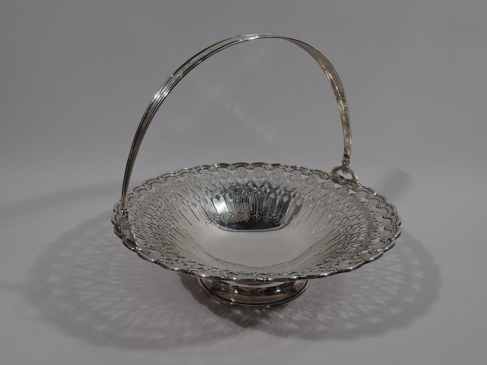 Large Edwardian Art Nouveau sterling silver basket. Made by Tiffany & Co. in New York, circa 1907. Bowl has solid center with engraved leaves and tendrils, surrounded by pierced interlaced scroll and leaf pattern heightened with engraving. Rim has