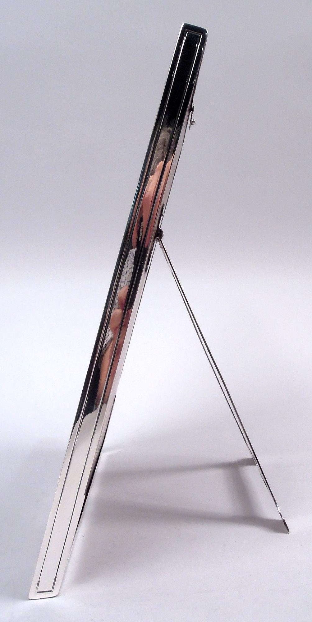 Cornice per foto in argento sterling in stile Art Nouveau edoardiano. Prodotto da Tiffany & Co. a New York, 1910 circa. Finestra rettangolare con cornice piatta. Sugli angoli anteriori fitte volute fogliate incise all'acido incastonate in cartigli