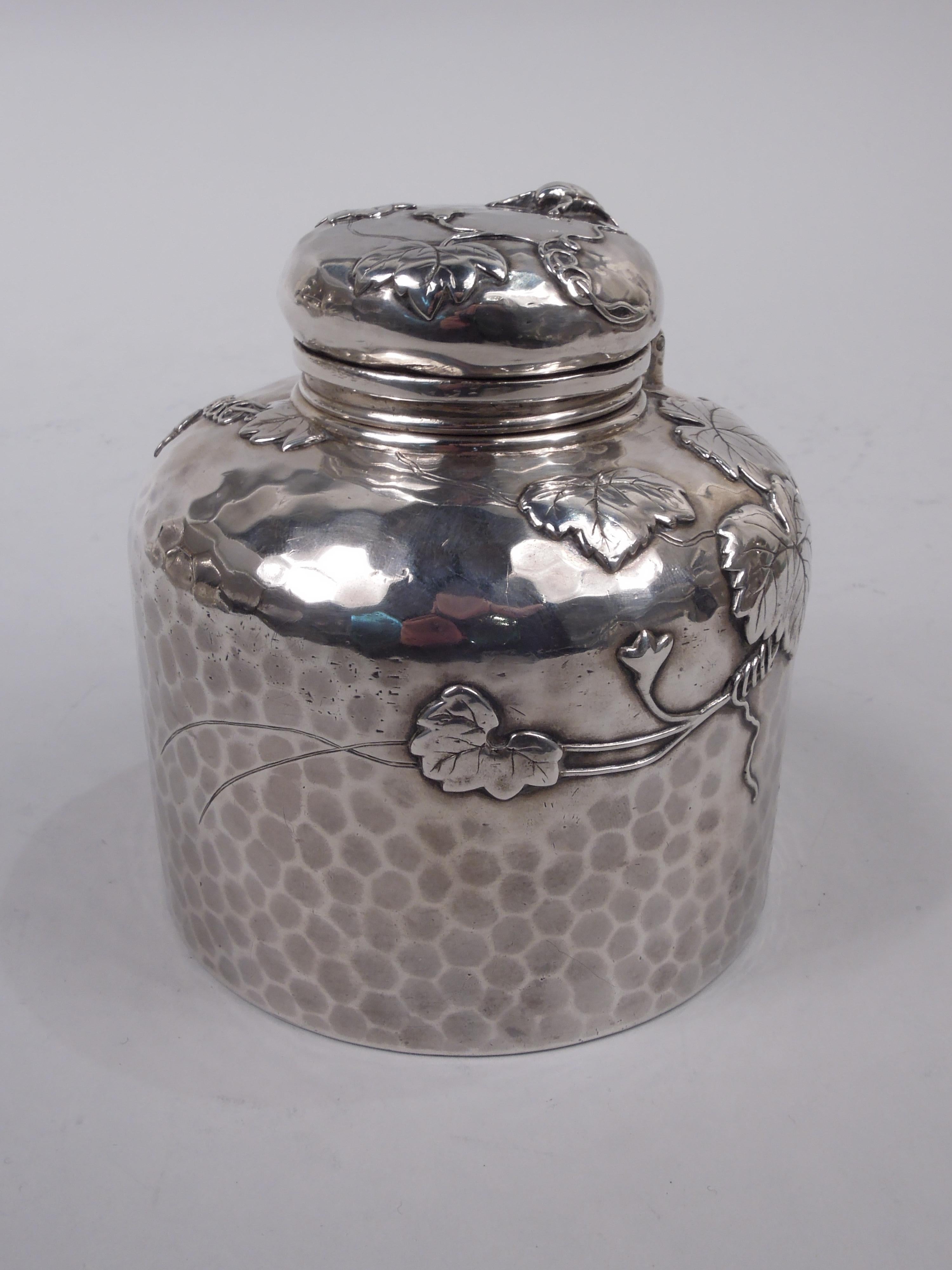 Japonesque sterling silver inkwell. Made by Tiffany & Co. in New York, ca 1882. Drum form with curved shoulder, short neck, and hinged and cork-lined bayonet cover. Leaves and tendrils and butterflies, too, applied to honeycomb hand-hammered ground.