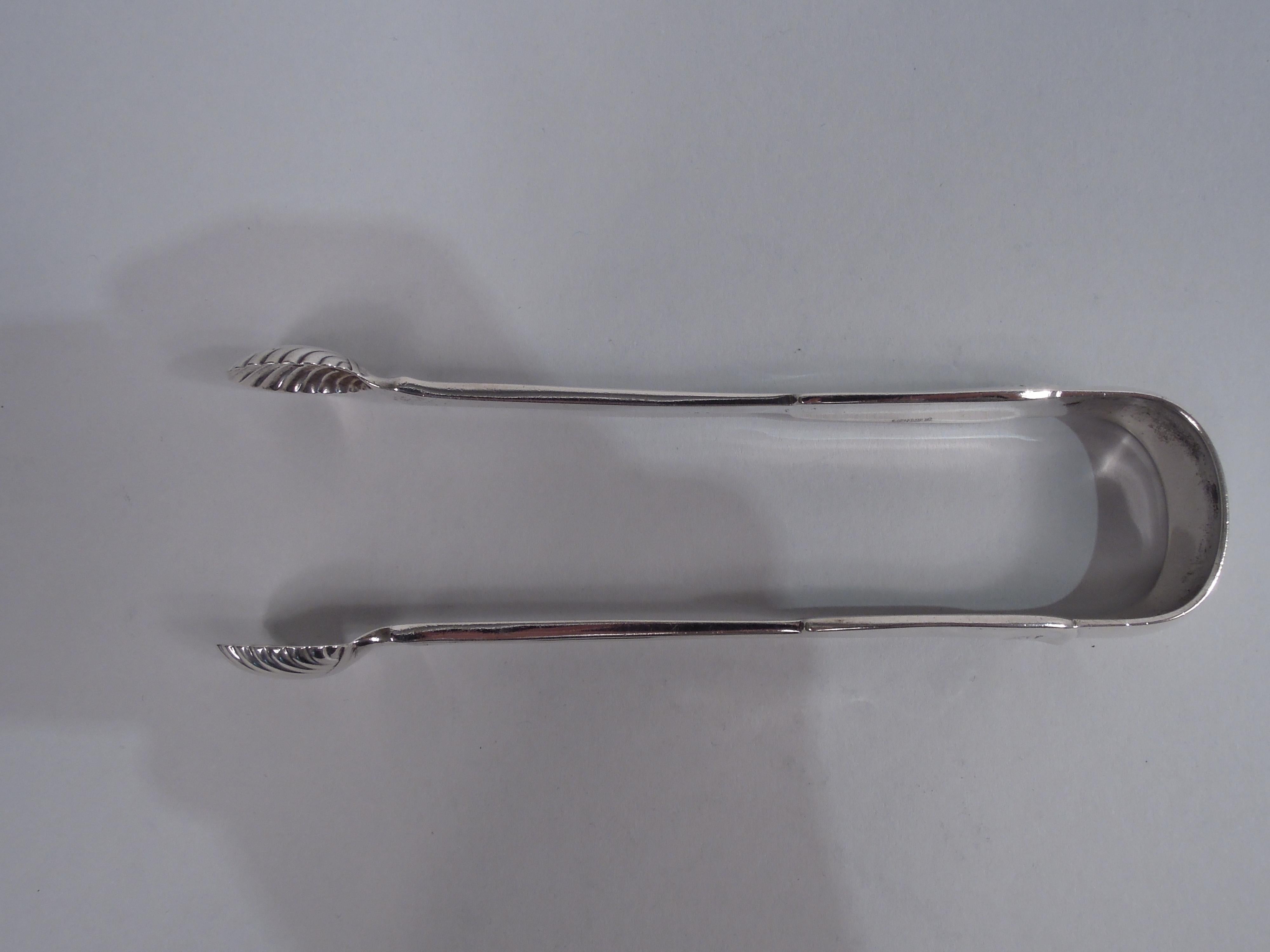 Large Palm sterling silver sugar tongs. Made by Tiffany & Co. in New York, ca 1880. U-form. Each stem tapering with scallop shell jaw; fiddle terminal with low relief palm. A rare serving piece in the simplified Classical pattern designed by Edward