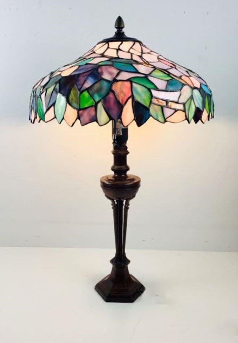 Fabulous table lamp with a beautiful hand-painted glass lampshade made with the Tiffany technique of multicoloured leaded crystals with leaf design on a patinated cast bronze elaborate base. France, 1950s. It takes one large E27 light bulb,