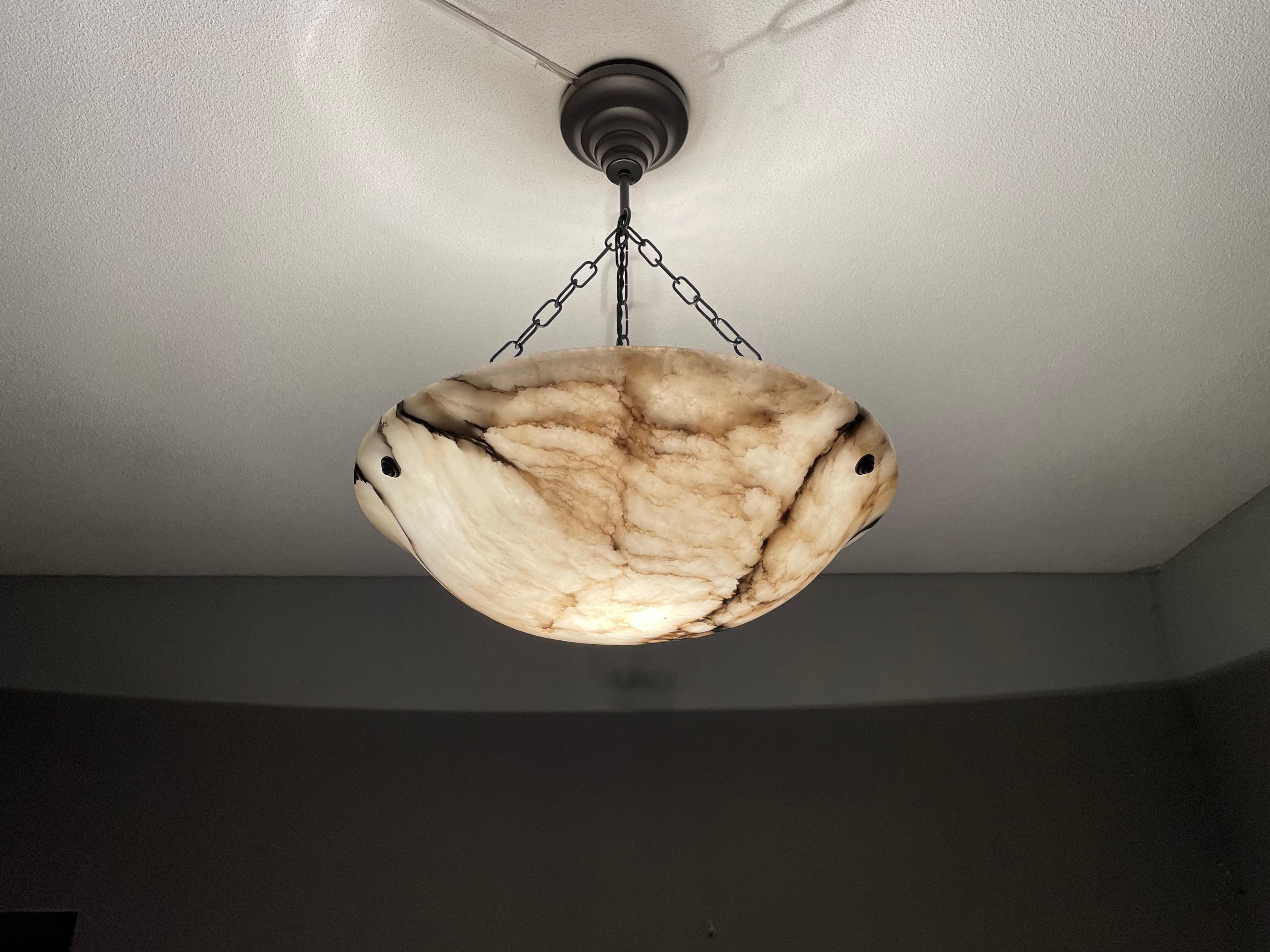 Large size and timeless, hand carved, antique alabaster pendant light.

Thanks to its 'calm' and timeless Art Deco design this alabaster chandelier will look great in all kinds of interiors. It is in very good condition from top to bottom and the